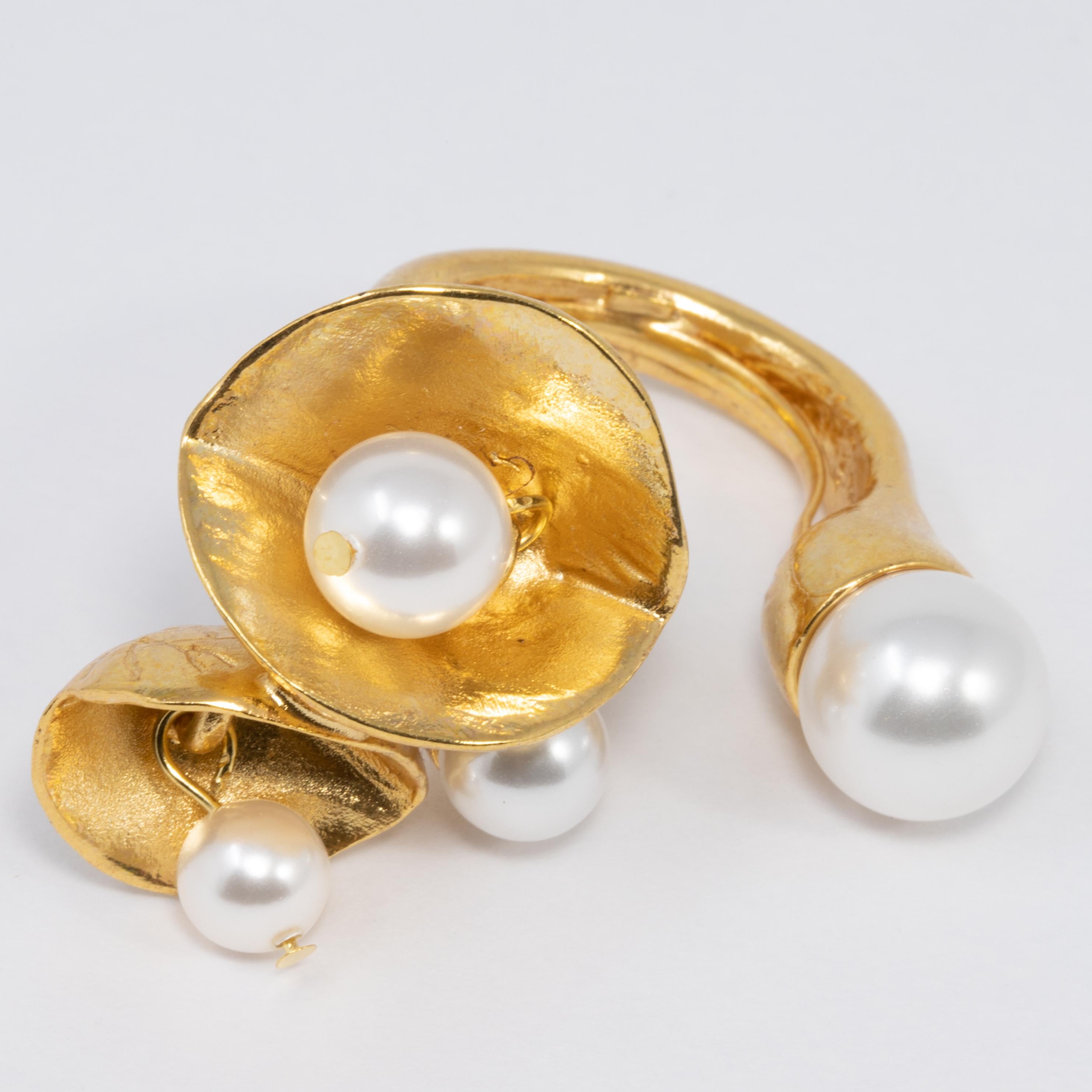 Oscar de la Renta golden, open-style cocktail ring with dangling faux pearls set in flowers.

Adjustable sizes 5 to 8.5

Tags, Marks, Hallmarks: Oscar de la Renta, Made in USA
