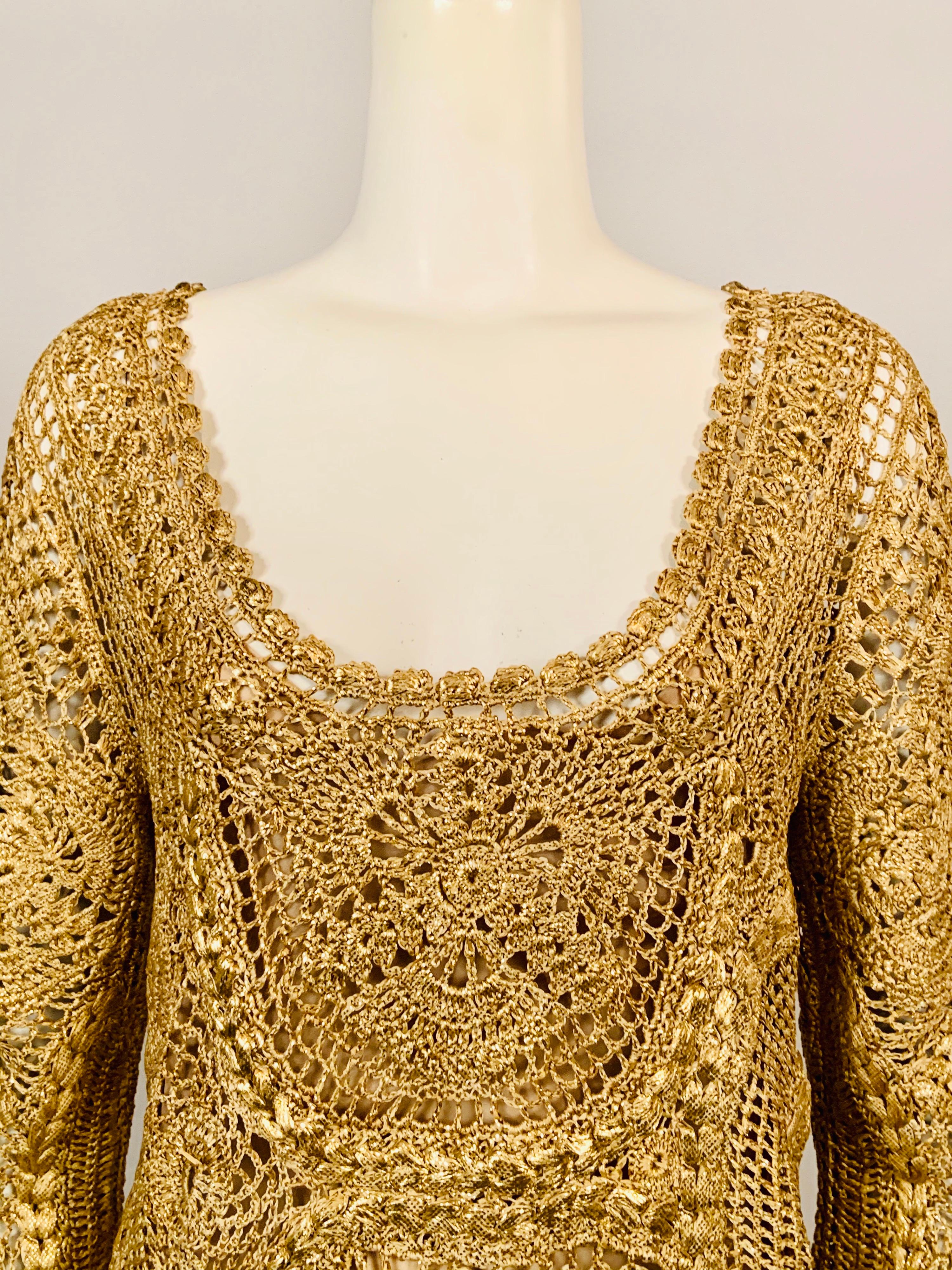 Oscar de la Renta designed a luxurious gold silk hand crocheted pullover tunic for the Spring 2010 collection. The top has a scoop neckline, three quarter length sleeves, and a scalloped hem.  It comes with a pale gold camisole made from two layers