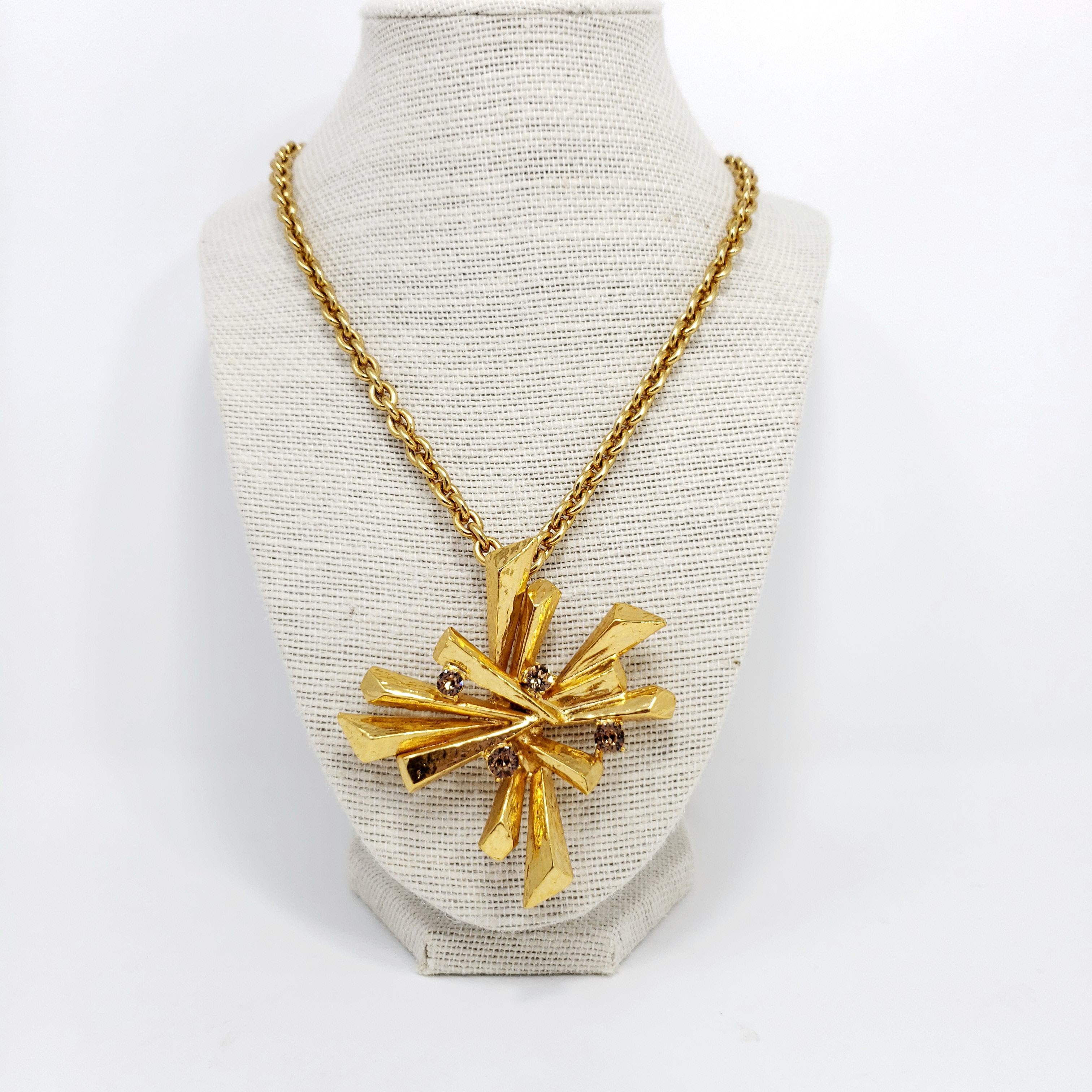 Stunning golden pendant rope necklace from Oscar de la Renta! The large abstract statement pendant is accented with topaz crystals.

Necklace is 30 inches around.

Marks: Oscar de la Renta, Made in USA