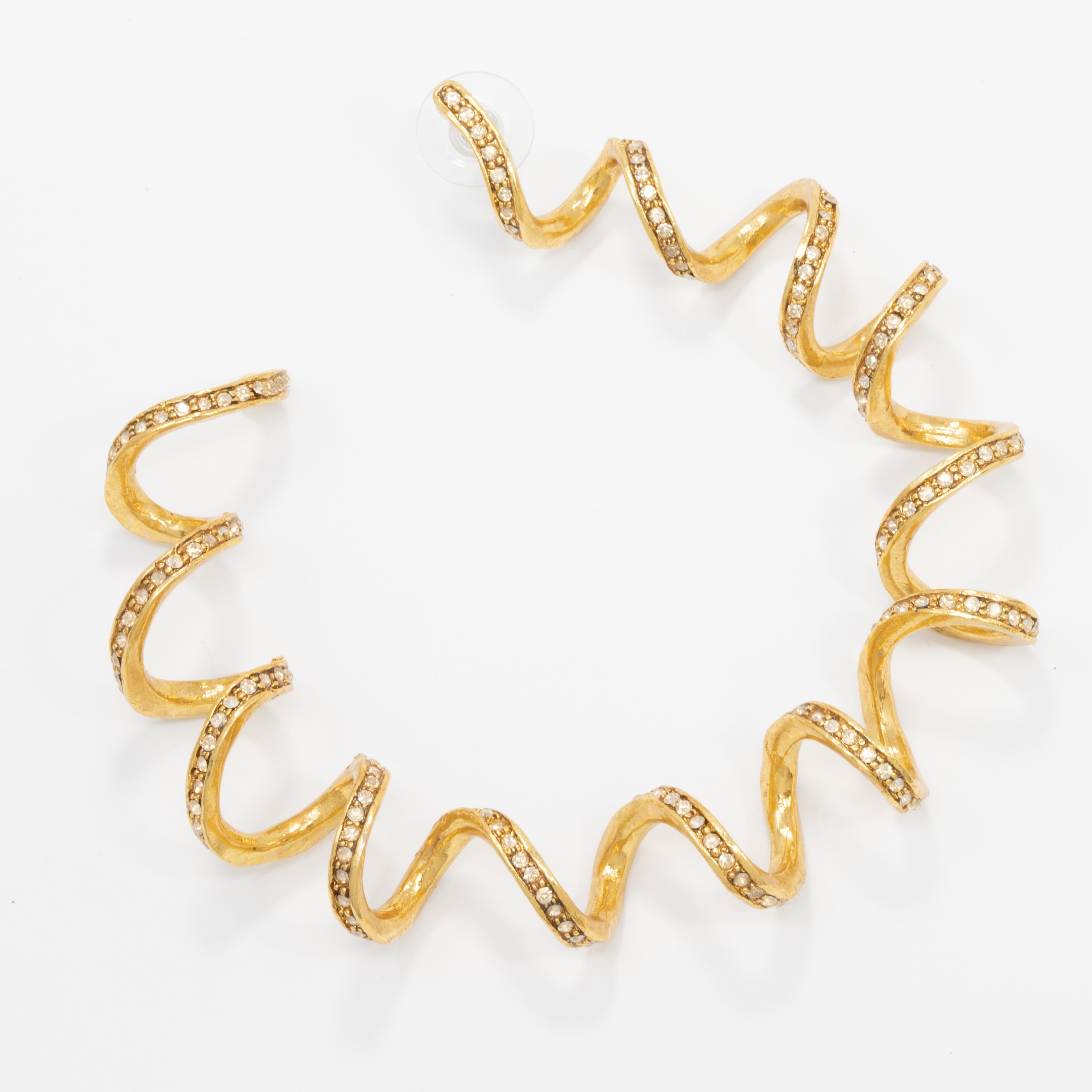 Bold twisted curl hoop earrings accented with clear Swarovski crystals. Add a golden glow to your outfit!

By Oscar de la Renta.

Gold plated. Post backs.

Hallmarks: none