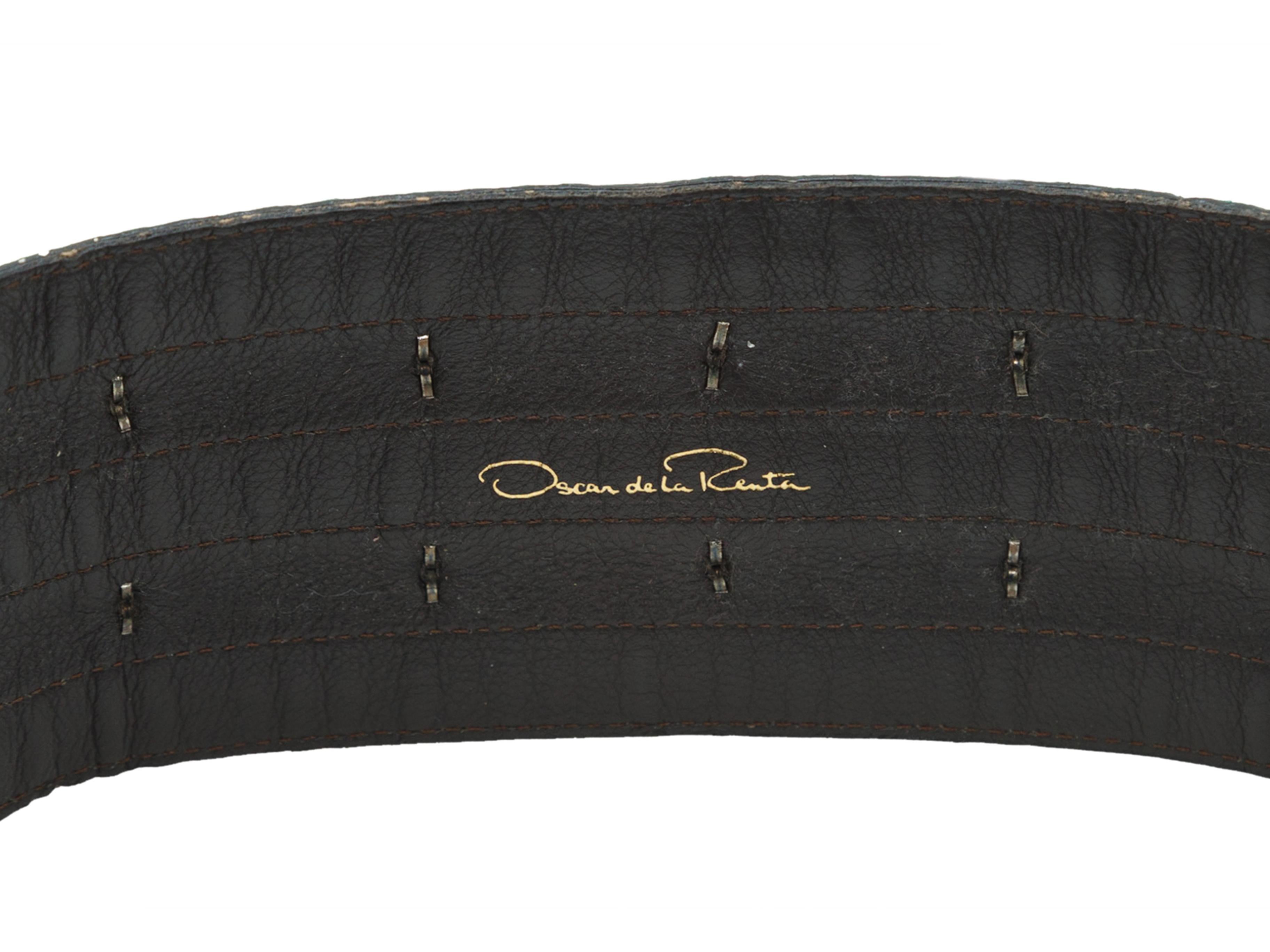Product details: Green and black snakeskin belt by Oscar de la Renta. Gunmetal stud embellishments throughout. Triple buckle closure at front. 27