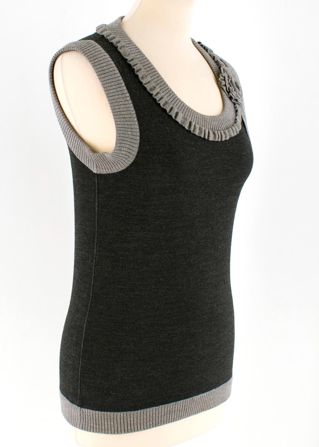 Oscar de la Renta Grey Wool Sleeveless Knit Top

- wool knit top
- sleeveless
- round neckline
- light grey rib trim
- knit flower embellishment to the collar

Please note, these items are pre-owned and may show some signs of storage, even when