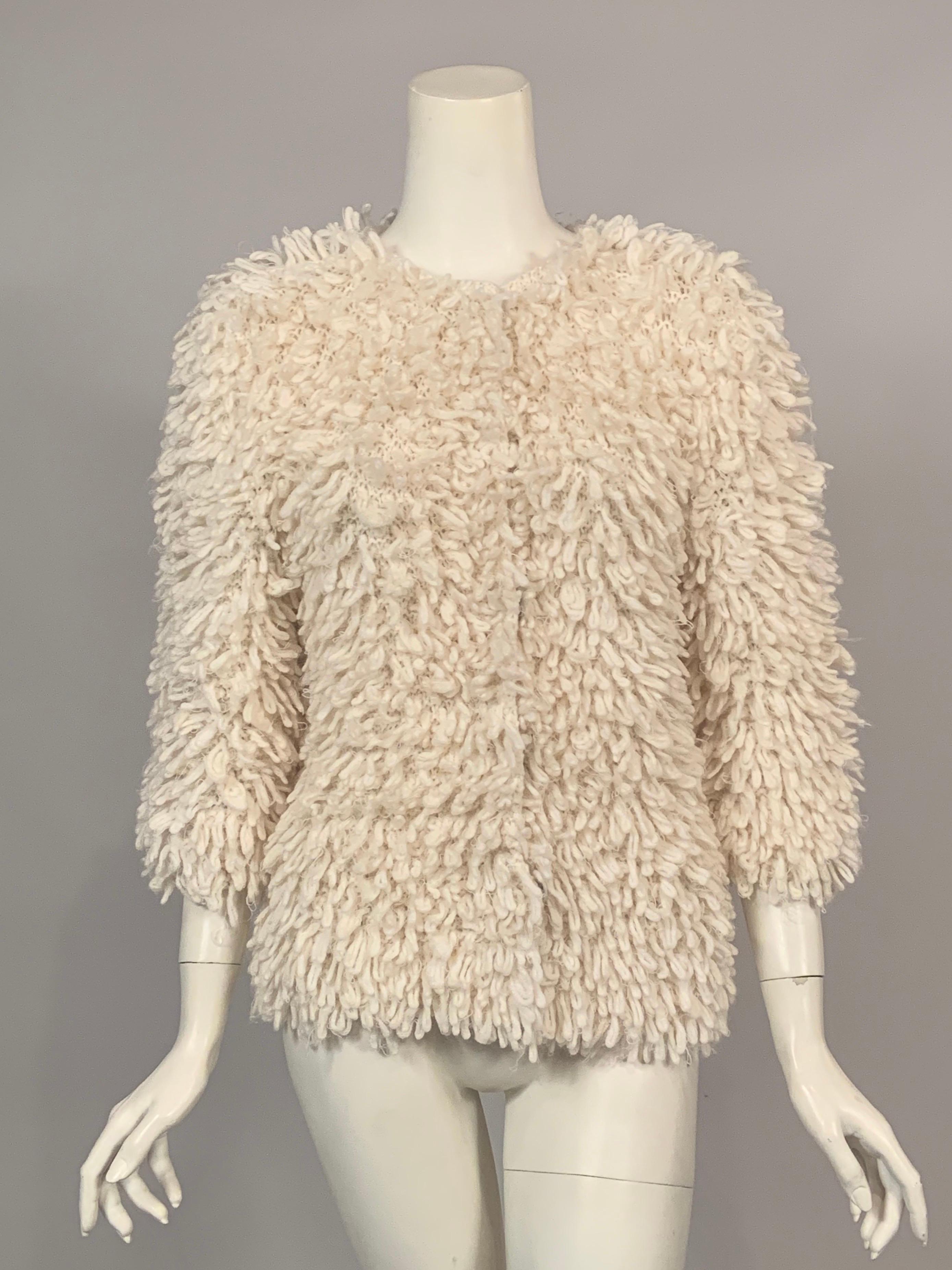 Creamy Cashmere and Mohair yarns in a 50/50 mix are hand knit into a cozy and fun sweater jacket designed by Oscar de la Renta. It has a fantastic looped yarn surface and closes at the center front with five oversized snaps. Never worn, it still