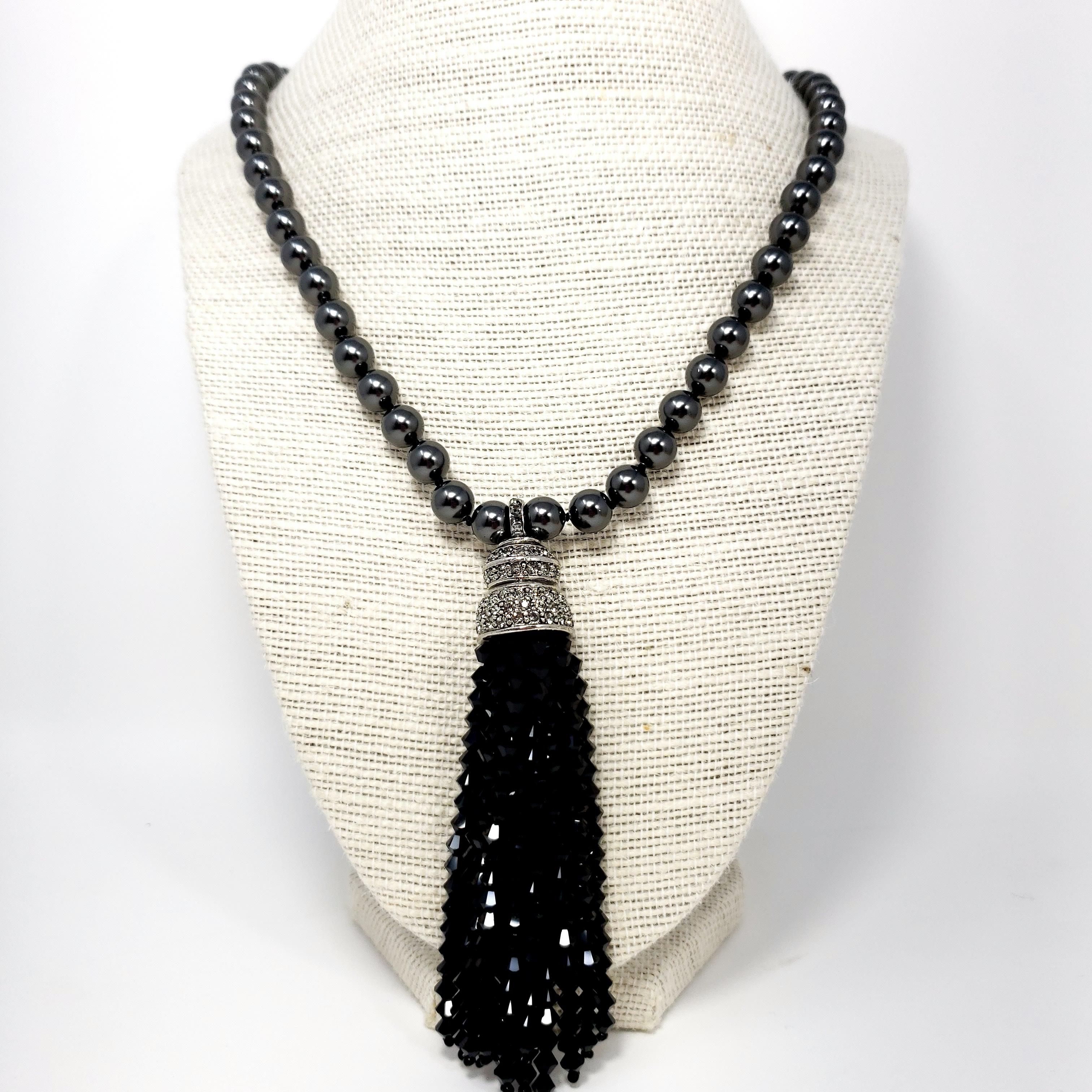 Black pearl, onyx and rhodium beaded tassel necklace from Oscar de la Renta.

A long, single strand of dark faux-pearls, connected with a rhodium pave-crystal ball fastening. Strands of onyx crystals hang off of a rhodium crystal-encrusted