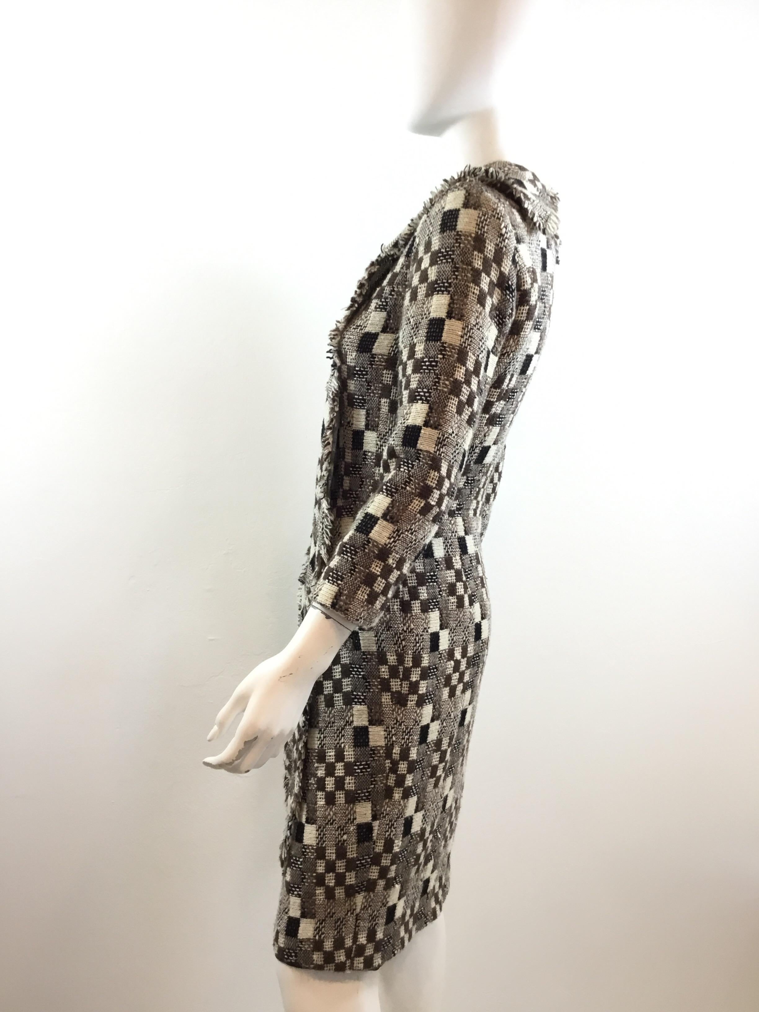 Oscar de la Renta knitted dress featured in a various thin of beige and brown colors throughout with an attached scarf at the neck. Dress has two pockets that have been uncut. Back zipper fastening and a full lining. Dress is a size 6, made in