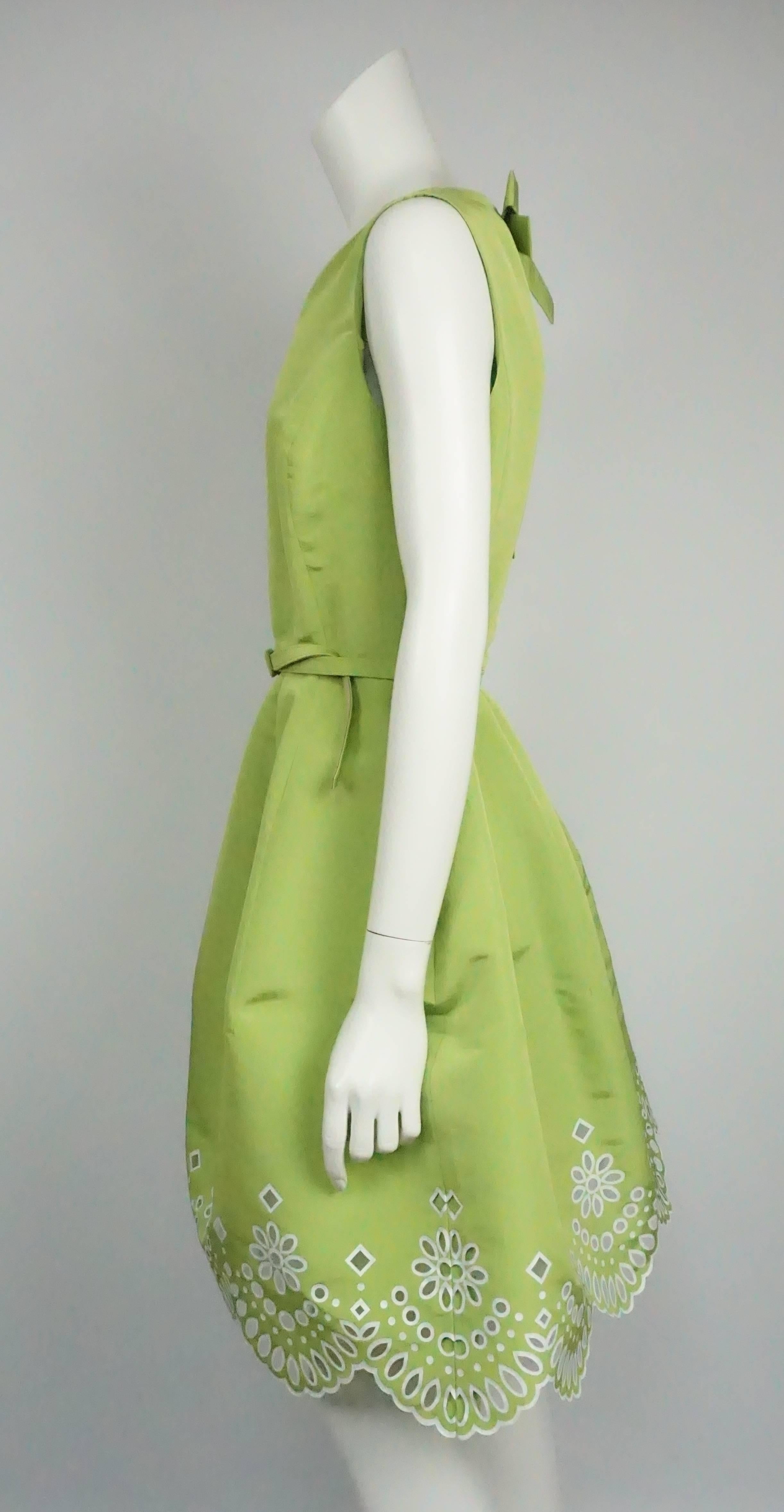 Oscar De La Renta Lime Green and White Eyelet Silk Chartreuse Dress - 10  This girly eyelet dress is made up of silk. It has no sleeves and cinches in at the waist with a removable belt. The skirt goes out into a bubble skirt and has two side