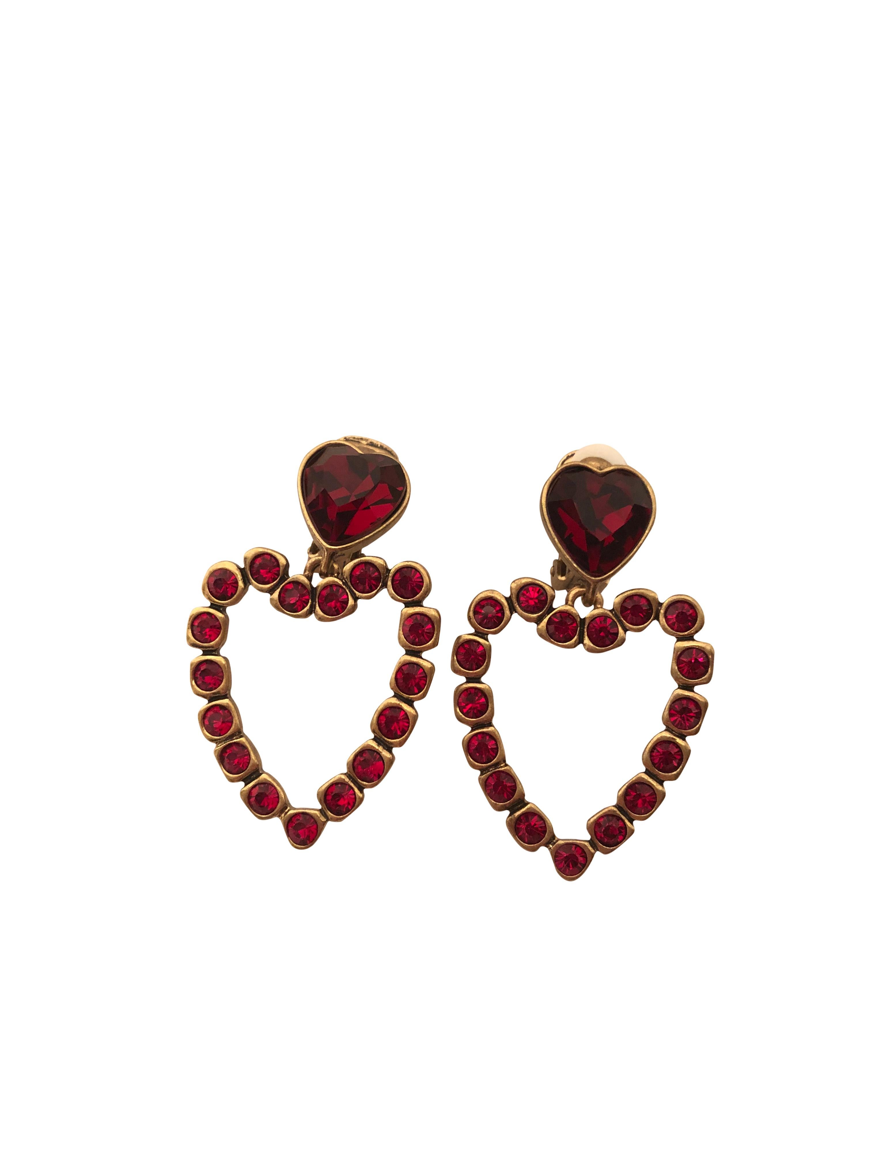 Stunning Oscar de la Renta love heart drop earrings with ruby red diamantes set in gold toned hardware. Clip on closure. Made in USA.

