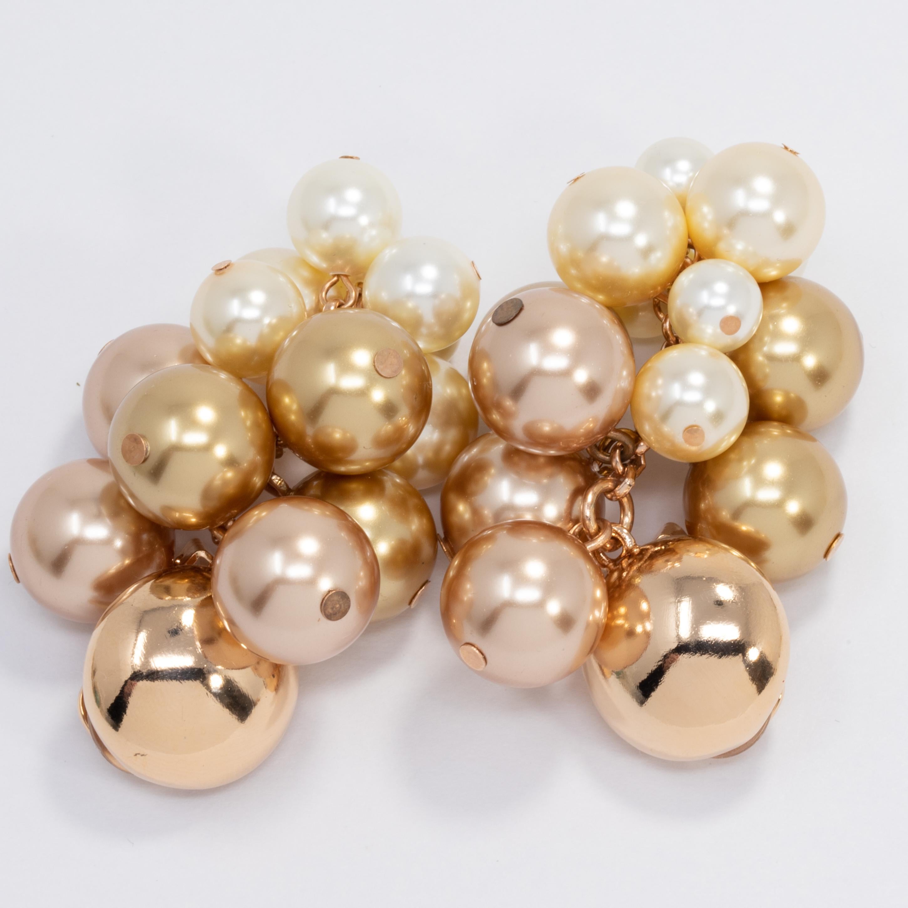 A pair of Oscar de la Renta clip on earrings. Each features a cluster or light-toned faux pearls of various sizes. Bold and stylish! 

Hallmarks: Oscar de la Renta, Made in USA