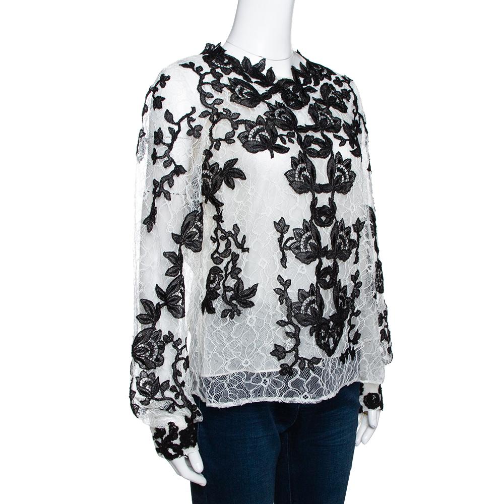 Oscar de la Renta's blouse in classic white hue exudes confidence and style in equal measure. It has a lace body with silk lining that gives it a feminine look and comfortable fit. The blouse also comes with contrasting black floral lace detail and