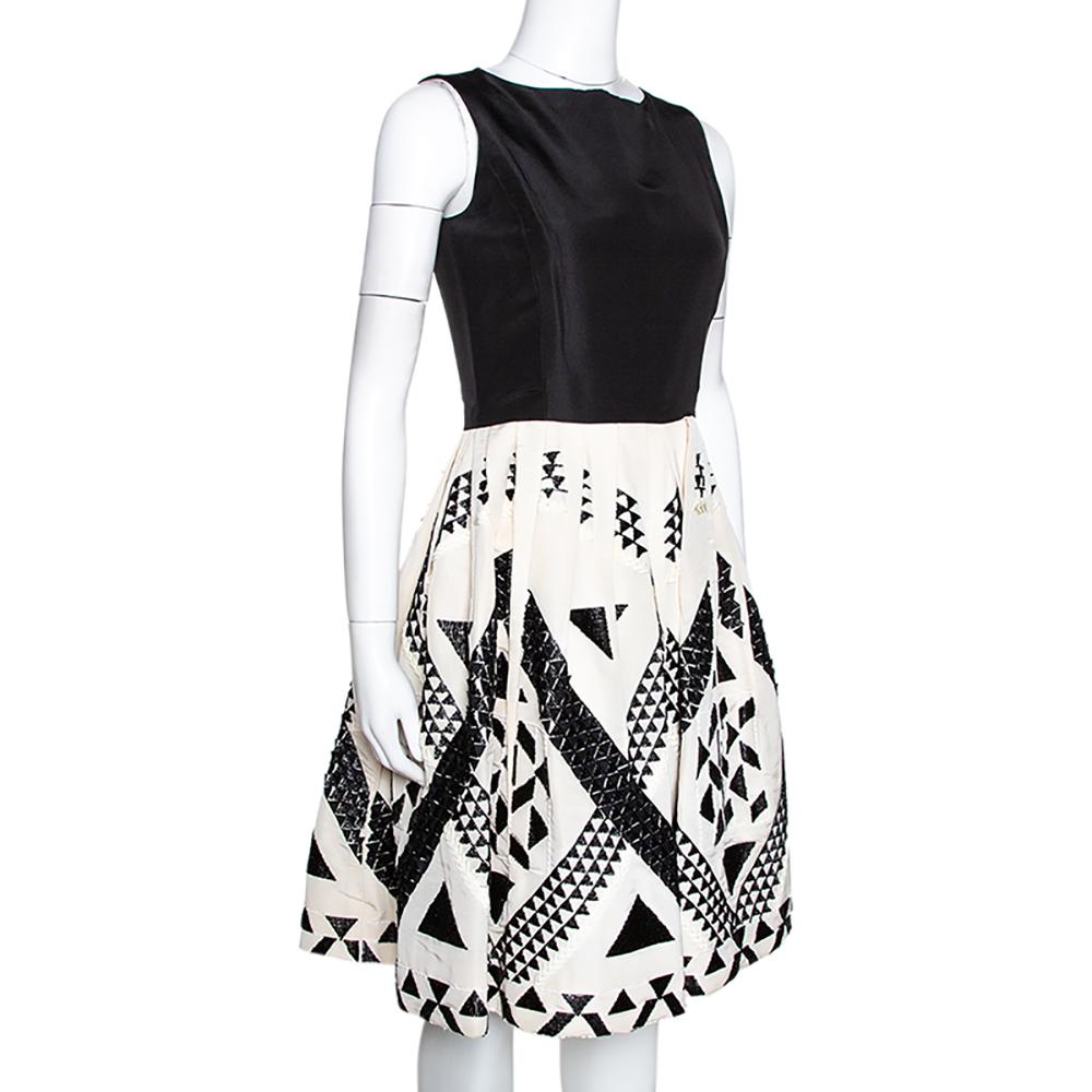 This Oscar de la Renta ensemble is a true example of the brand's sophisticated designs. Look vibrant and sport a confident look with this cool sleeveless dress. Crafted from 100% silk, it comes in a monochrome color scheme. It is styled with a