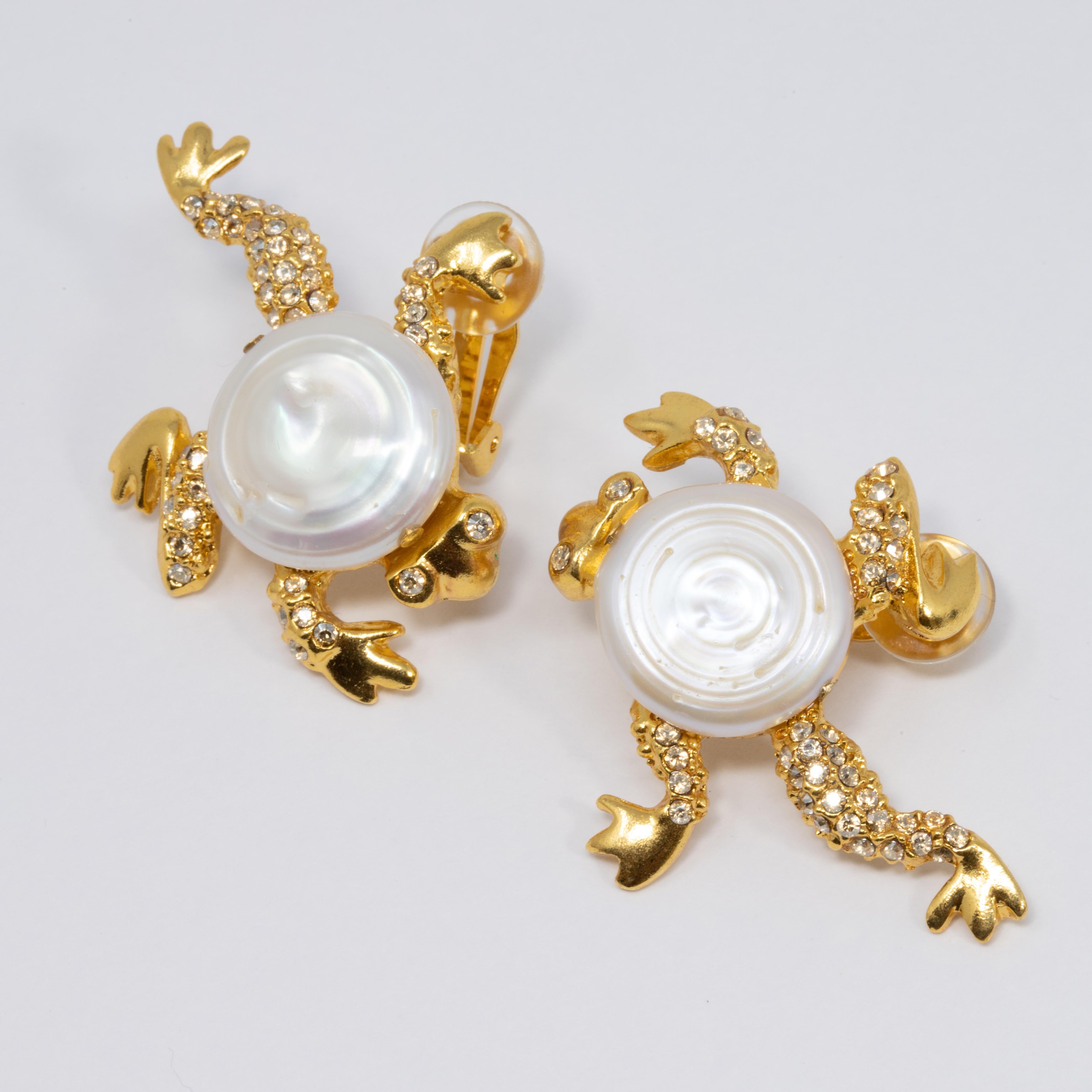 A pair of gold bold clip on earrings by Oscar de la Renta! Each frog features a mother of pearl centerpiece, accented with clear crystals.

Hallmarks: Oscar de la Renta (on both), Made in USA (on one)