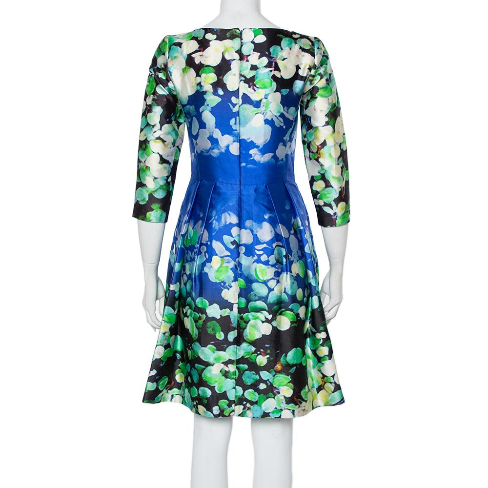 This dress comes from the iconic label of Oscar de la Renta. It has a stylish silhouette and is made from cotton & silk in vibrantly hued floral print. It has a sleek neckline, pleat detailing, and a zip closure at the back. Pair it with pointed