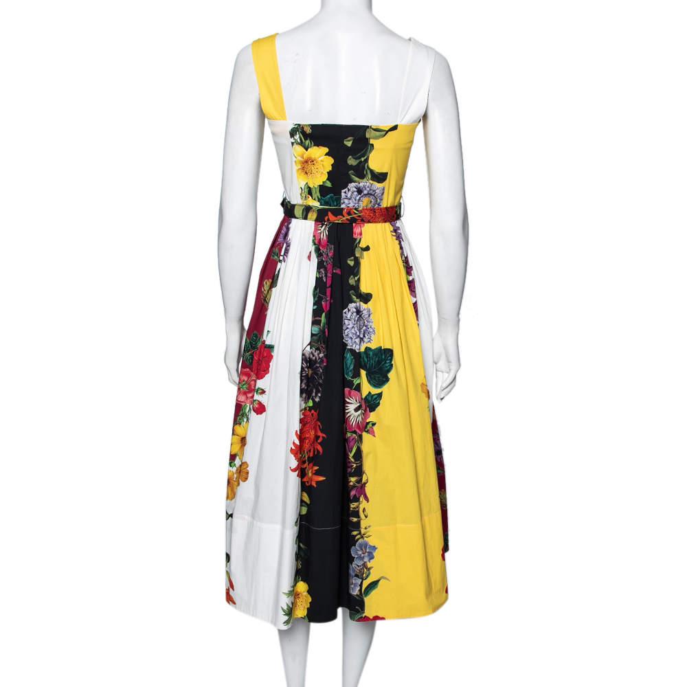 Oscar de la Renta brings you this beautiful dress to flaunt elegance and grace no matter what! It is designed using multicolored floral printed cotton fabric, which is embellished with pleated formations and a button-front feature. It has a belted