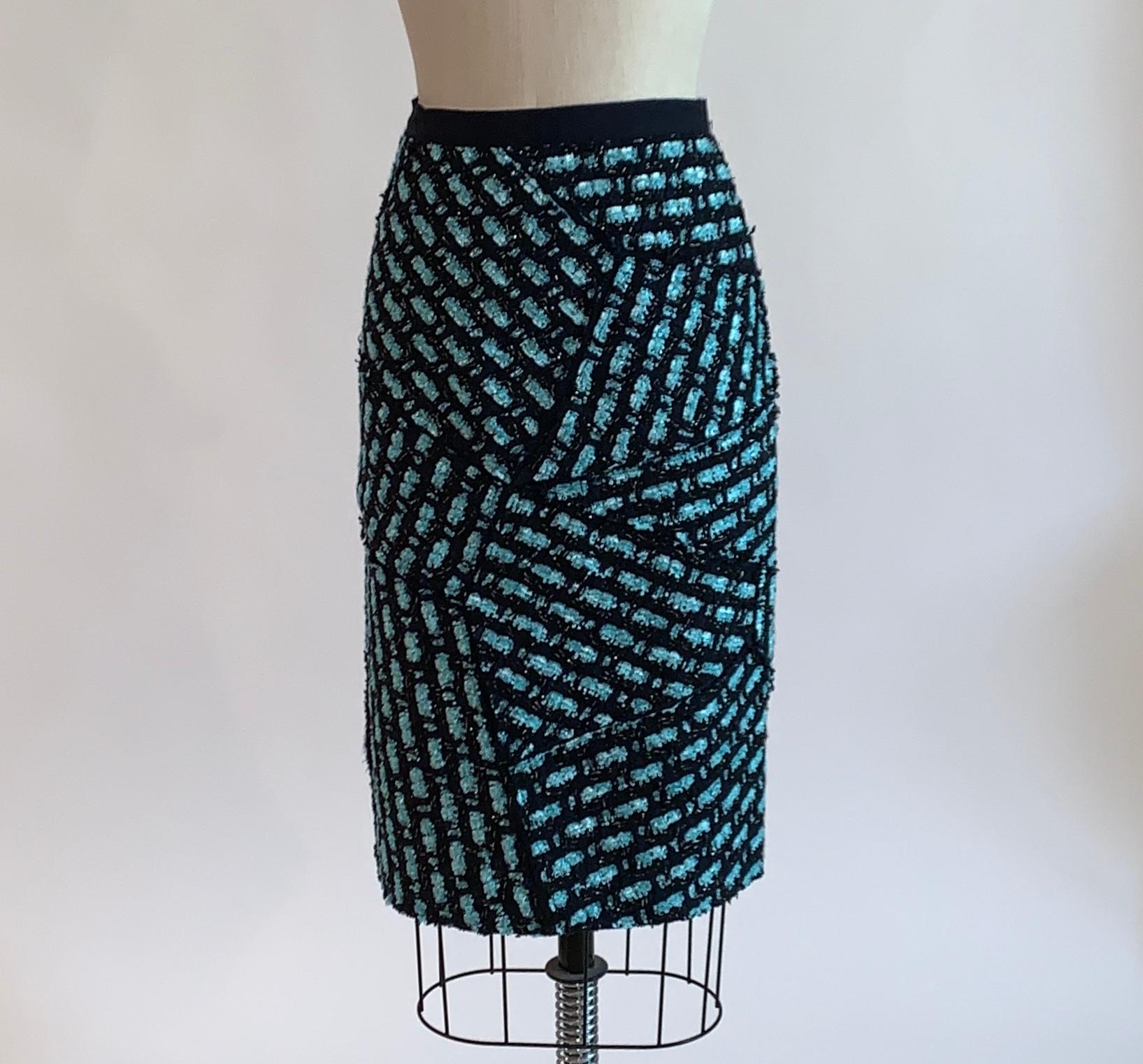 Oscar de la Renta deep navy (almost black) and sky blue pencil skirt with tweed patchwork appliqué with sky blue and silver accents. Very slight asymmetric back hem due to the patchwork style. Grosgrain band at waist, back zip and hook and eye