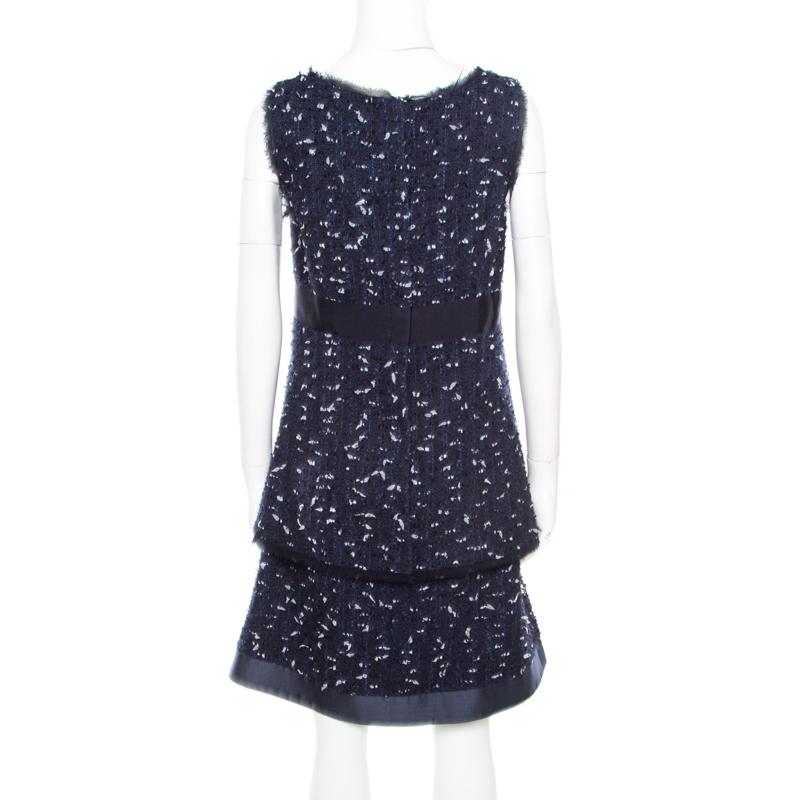 Isn't this sleeveless dress from Oscar de la Renta just lovely? This navy blue boucle tweed dress features a chic design and flaunts a scooped neckline, twin slip pockets, and a tiered bottom silhouette. It is sure to look amazing on you and can be
