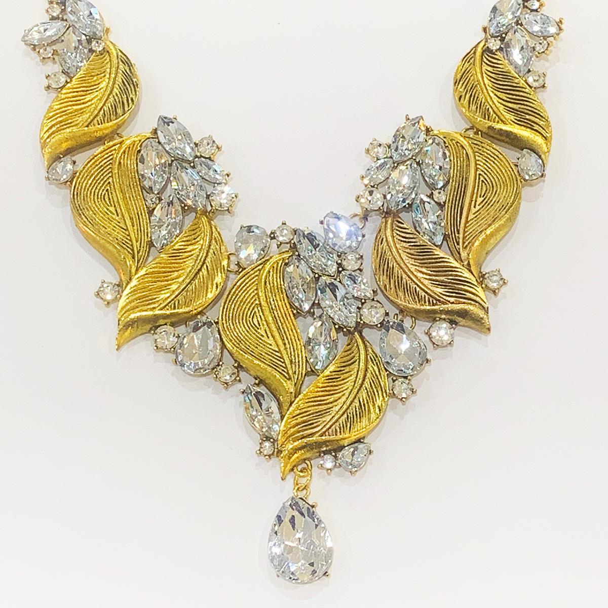 Genuine Oscar De La Renta Necklace Gilt Leaves with White Mirror Diamantes, in elongated octagonal shape of different sizes and a larger pendant with large white crystal Teardrop diamante. The  “pendant” area is made of 5 segments; 1 decorated leaf