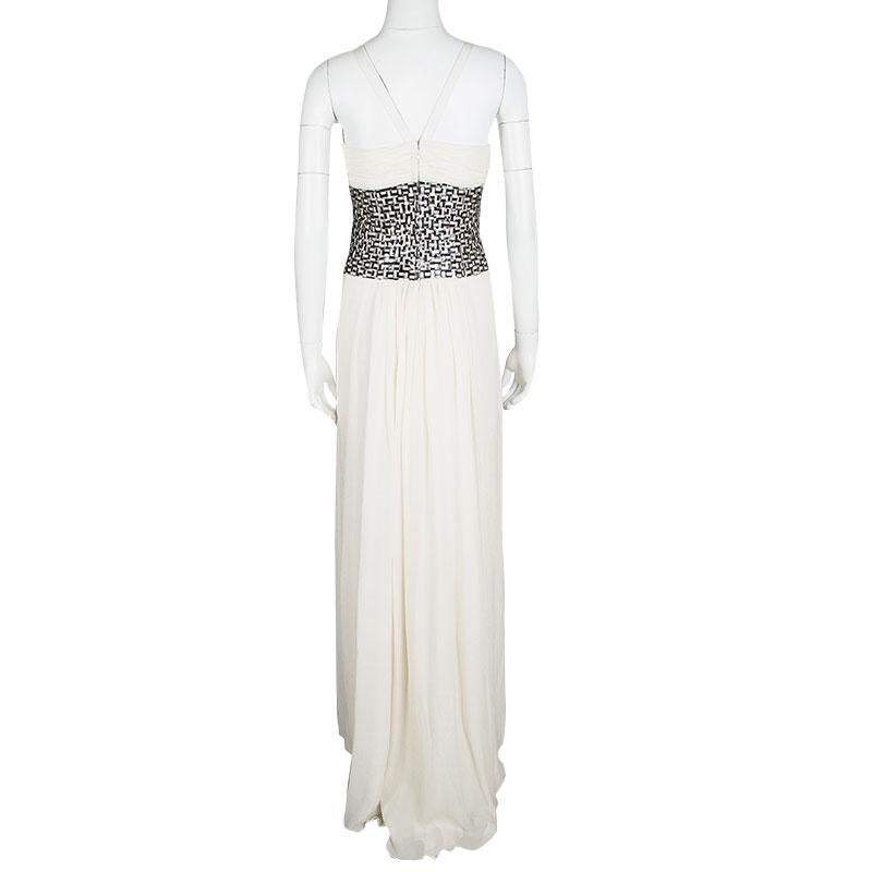 Designed in the most gorgeous off white silk fabric, this Oscar De La Renta gown will instantly make you ready for the special event. Featuring halter straps with V cutout at the top, this gown is accented with black and white basket weave