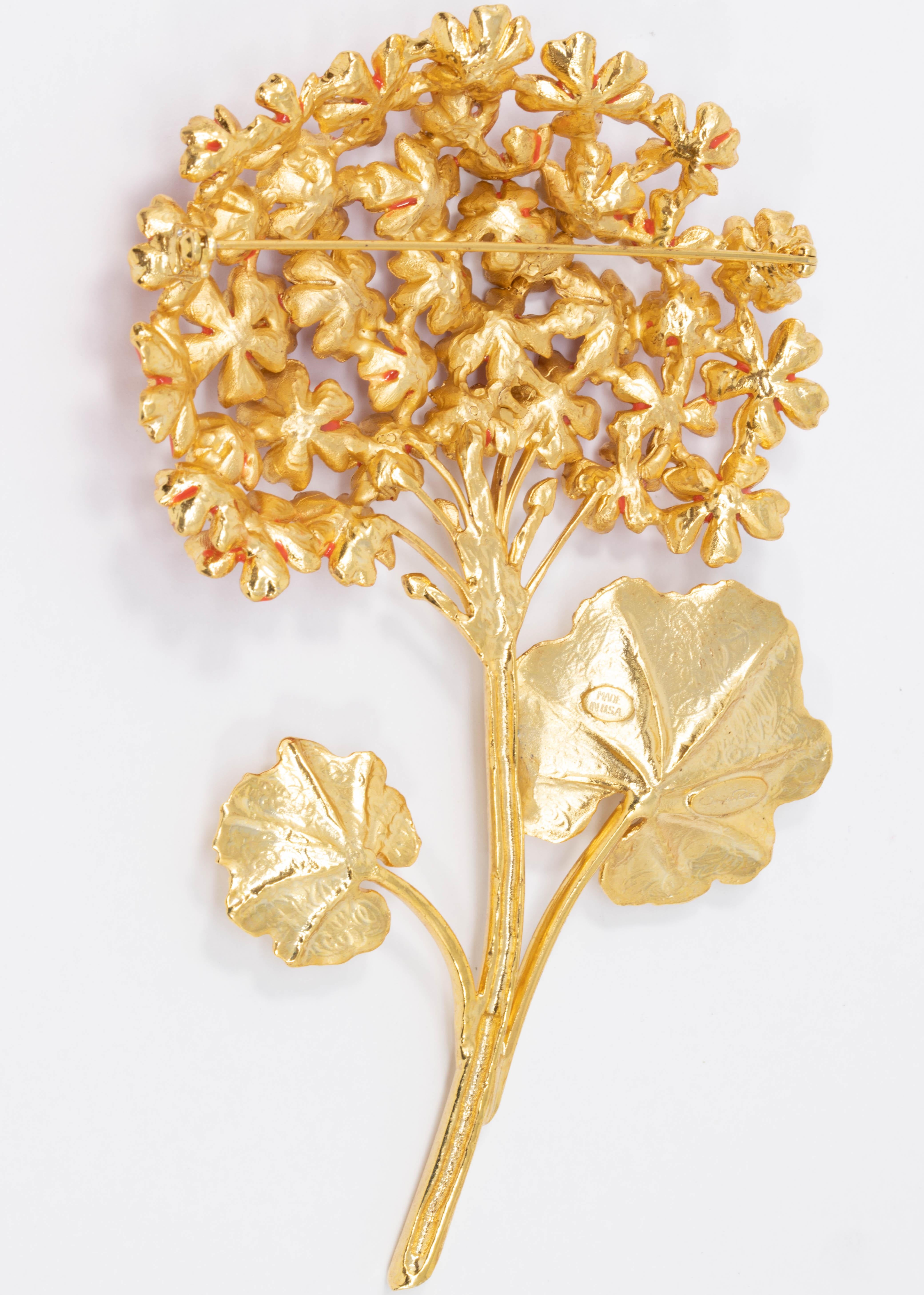 A magnificent bouquet of flowers! This Oscar de la Renta pin brooch features geranium flowers on a golden stem.

22KT gold plated. Hand-painted cayenne orange enamel.

Tags, Marks, Hallmarks: Oscar de la Renta, Made in USA