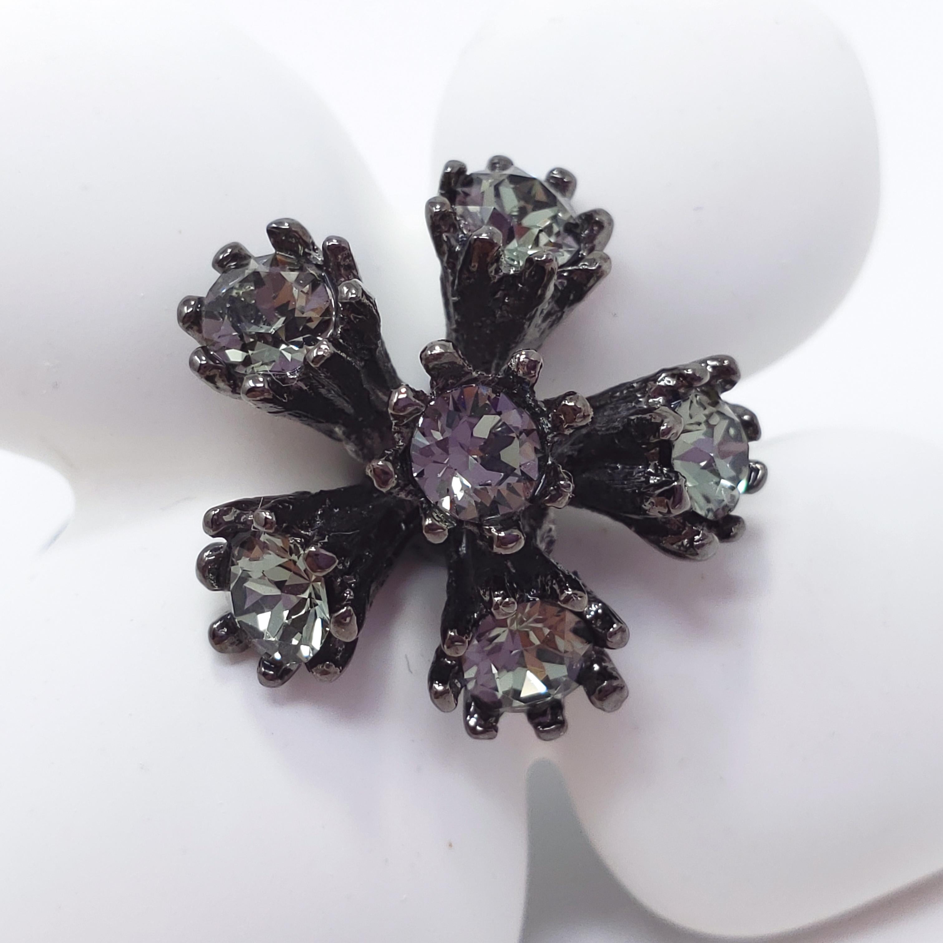 A grapefruit flower ring by Oscar de la Renta. Feature white resin petals accented with gray crystals on a textured dark gray brass setting.

Size: Adjustable, US sizes 4-8
Flower height approx 1.5 inches
Hallmarks: Oscar de la Renta, Made in