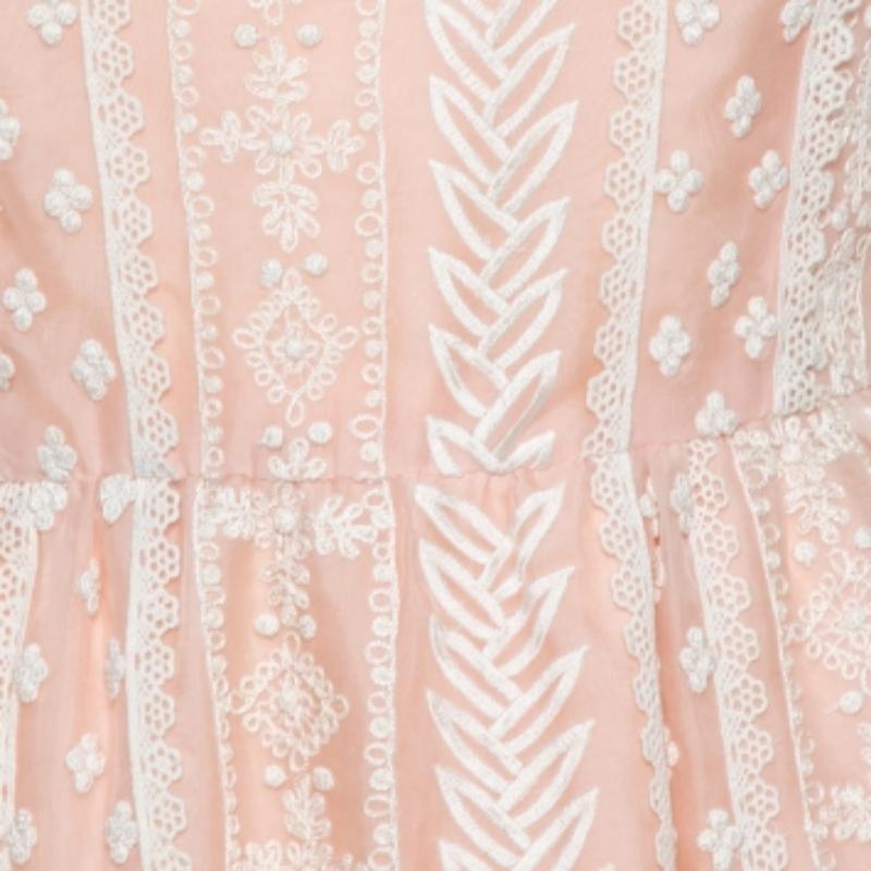 Elegant and simply breathtaking, this Oscar de la Renta creation is an absolute masterpiece. It has been crafted from pure silk organza and comes in a lovely shade of pale pink. This sleeveless dress has an embroidered exterior, a simple neckline, a