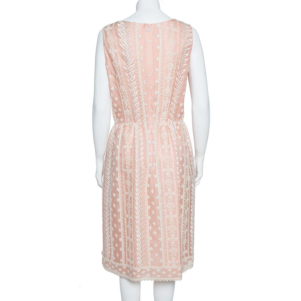 Elegant and simply breathtaking, this Oscar de la Renta creation is an absolute masterpiece. It has been crafted from pure silk organza and comes in a lovely shade of pale pink. This sleeveless dress has an embroidered exterior, a simple neckline, a