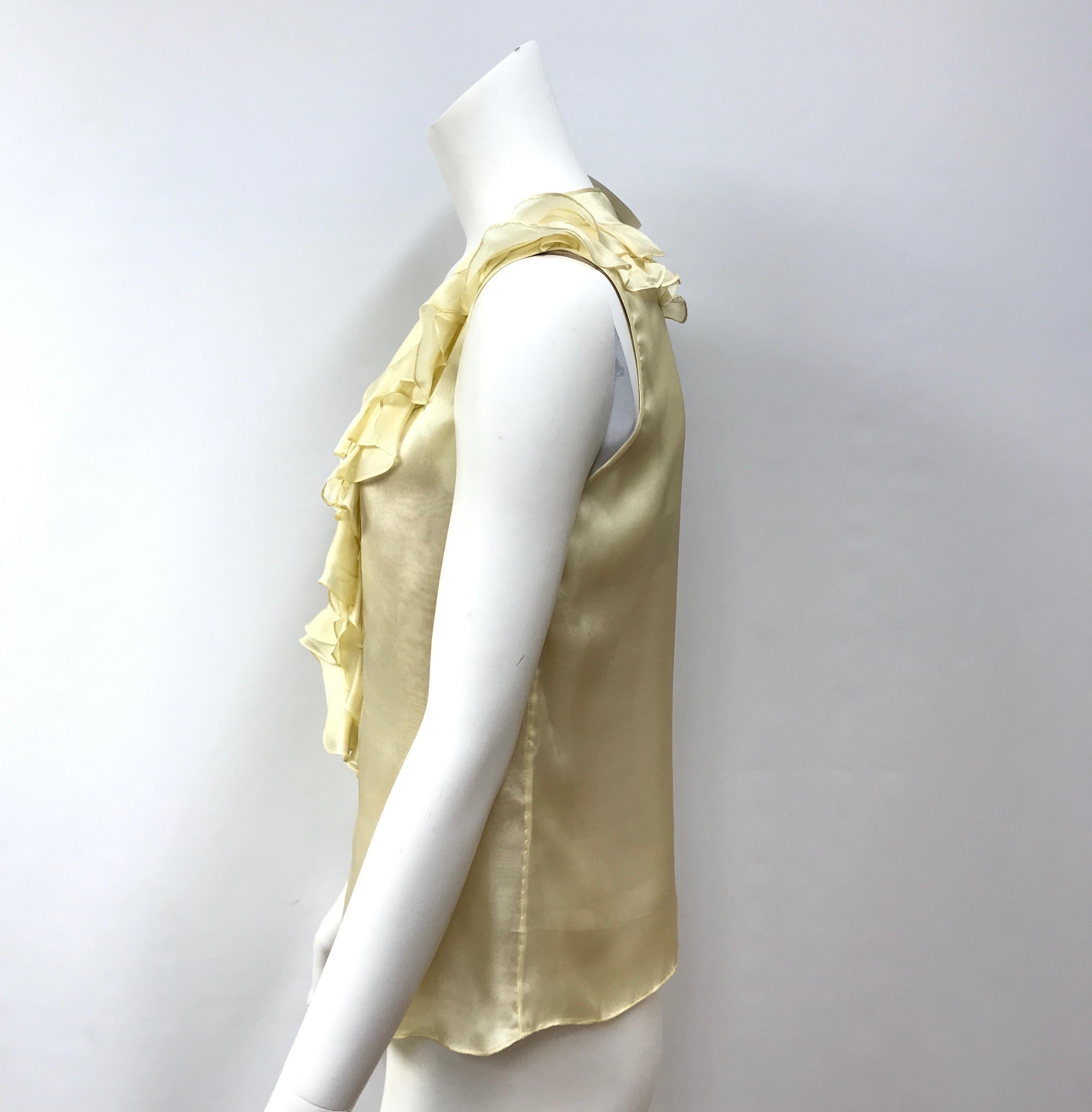 Oscar De La Renta Pale Yellow Silk Sleeveless Top-6. This Oscar De La Renta top is in excellent condition, it shows no sign of use. It is made of a light or pale yellow silk. It is sleeveless and has front ruffle detailing. There is a 