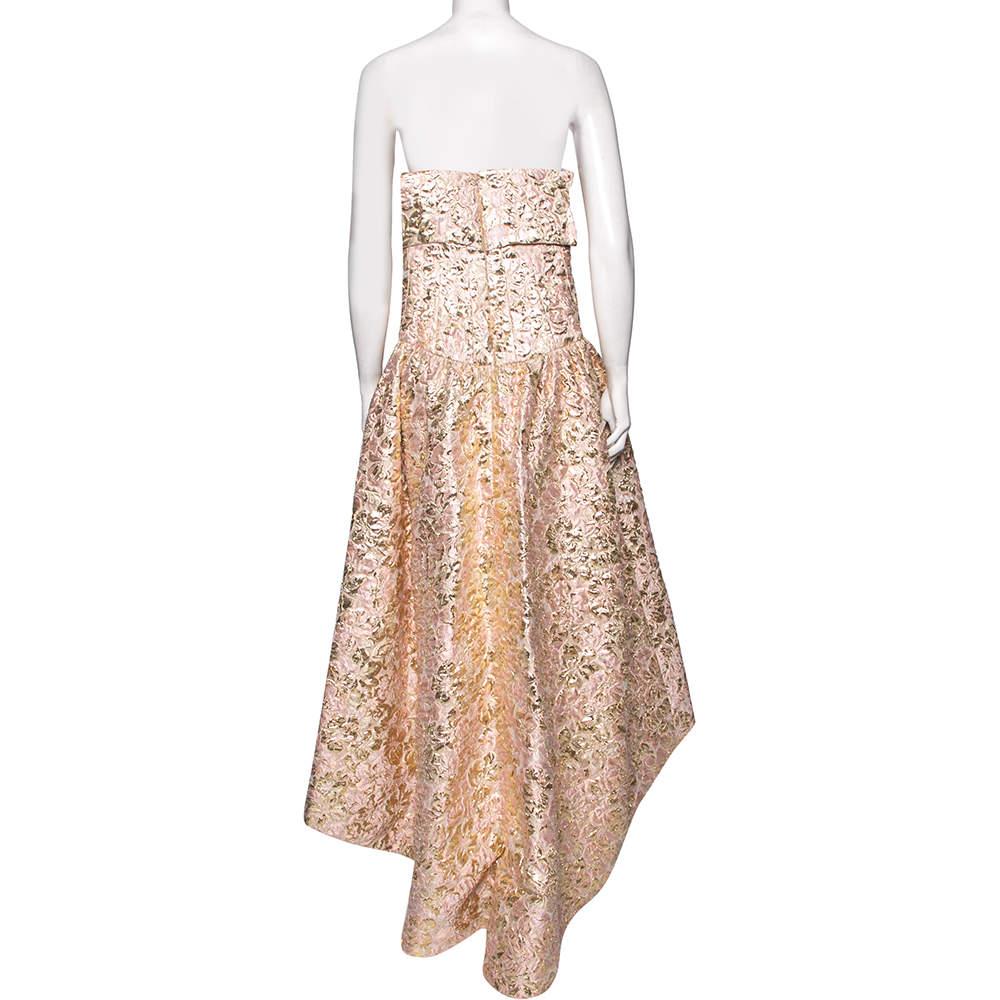Make a unique style statement by wearing this fabulous gown from the House of Oscar de la Renta. Fashioned in pink and gold brocade fabric, this gown exhibits a strapless style with an asymmetrical silhouette. For closure, it is equipped with a