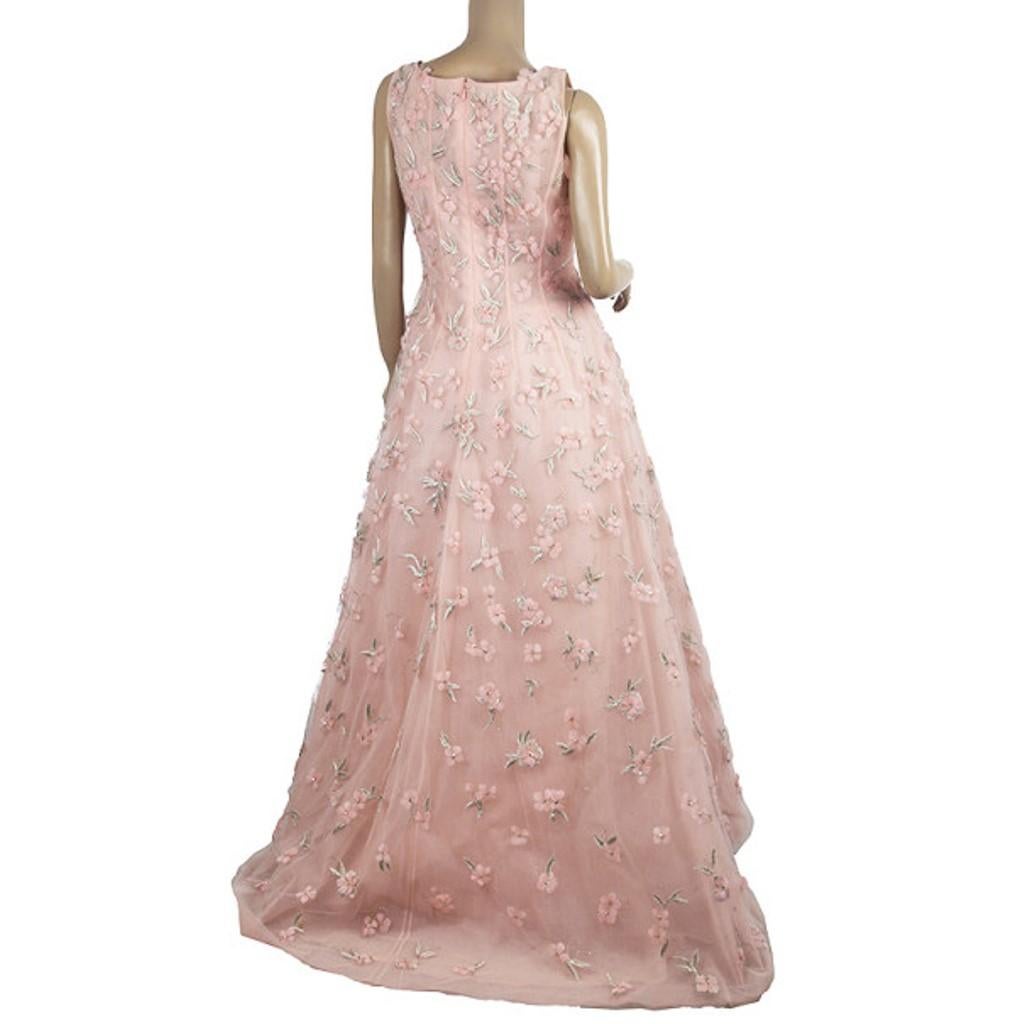 This fairy tale inspired gown by Oscar de la Renta is from the 2013 Spring collection. It is made from silk in a sublime pink color and showcases embellished embroideries. This sleeveless gown comes with a separate underlay, an uneven hem which is