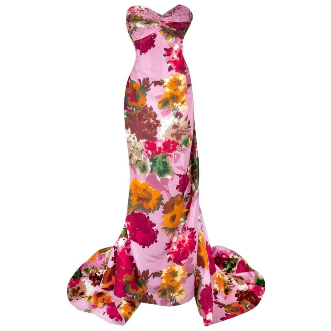 Oscar de la Renta - Pink silk garden party dress is a perfect introduction to spring.  The pink silk fabric explodes with a vibrant floral bouquet of color.  The the long slender figure hugging dress is made with a built in boned corset and an