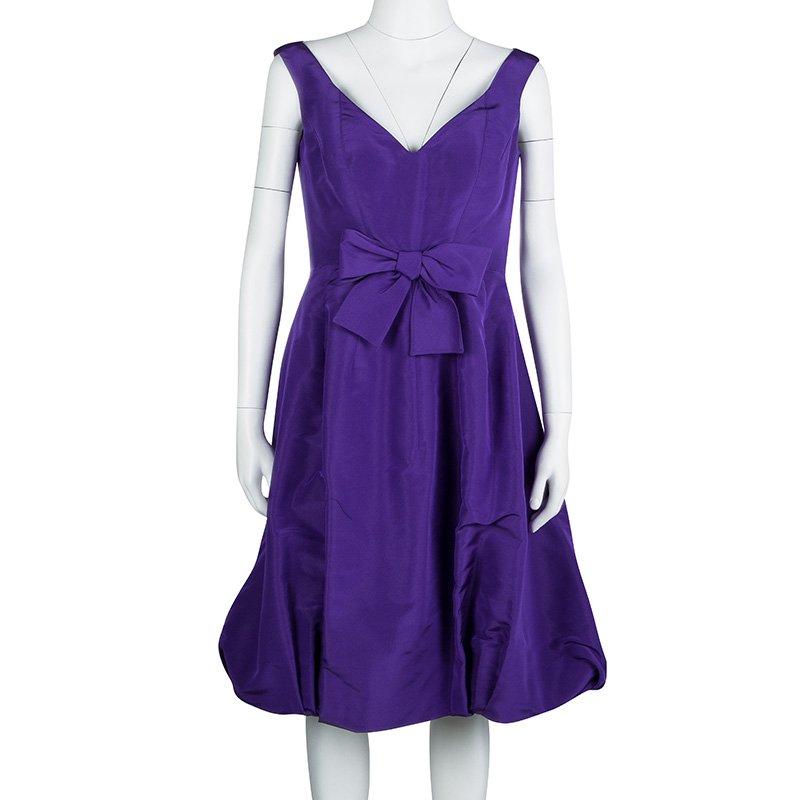 Elegant and classy, this is one dress that every woman dreams of having. Beautifully made from silk, this Oscar De La Renta sleeveless dress has a lovely purple hue, a V neckline and a bow at the front. It also has a calf-length hem which will make