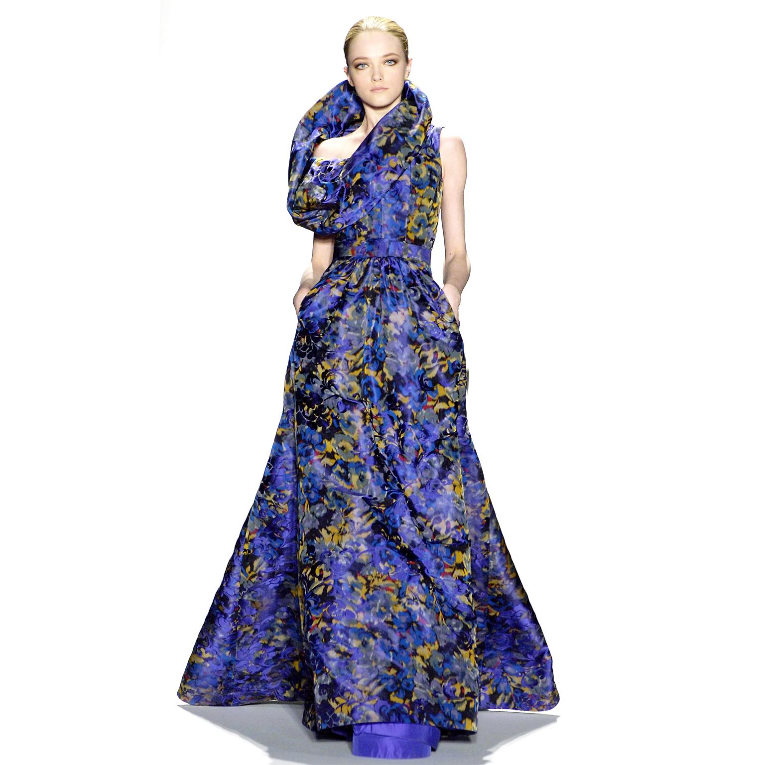This purple floral Oscar de la Renta dress is incredibly unique and has a very flattering silhouette. We are showing it in a long version presented during the Fall Winter Oscar de la Renta runway show.The dress has a very structured and has a