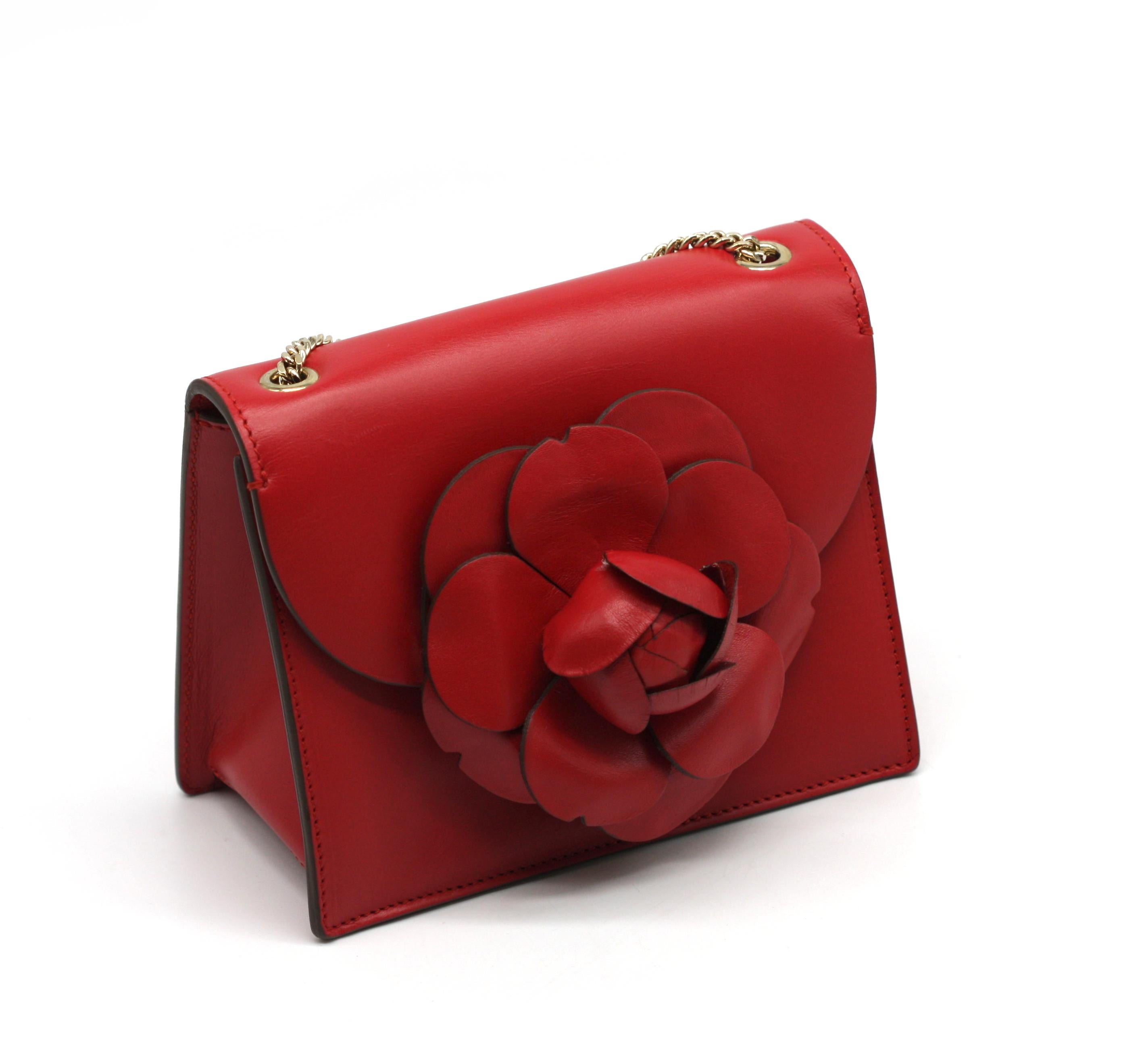 Oscar De La Renta Rote Saffiano Leder Flora Handtasche 
 Die Klappe mit einer aufgesetzten Blumenblüte aus Leder, mit goldfarbenen Beschlägen, Druckknopfverschluss, auf der Rückseite mit eingekerbtem Schlitzfach, innen rotes Leder, ebenfalls mit