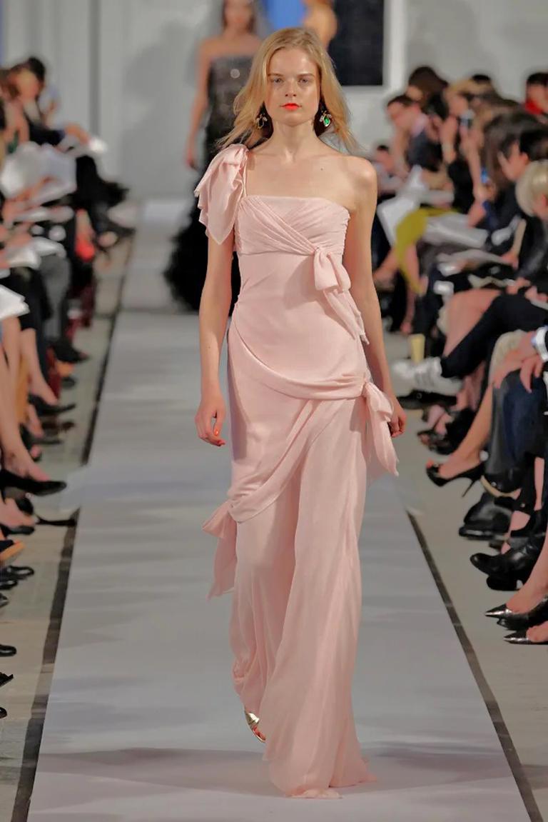 An ethereal one shoulder Oscar de la Renta 2012 evening gown as seen in the Resort runway show.   Adorned with pleated and ruffle accents; short sleeve with one shoulder. Concealed side zip closure.  Faint raw edges as part of the design.  A lovely 