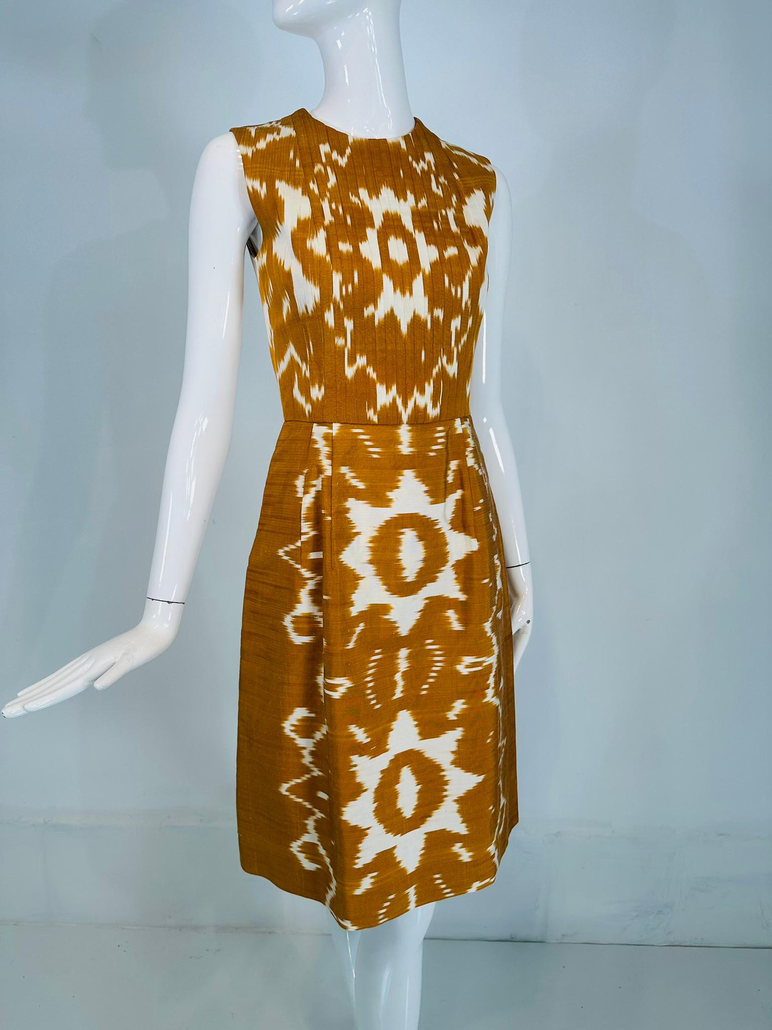 Vestido sin mangas Oscar De La Renta S/S 2008 de seda flameada dorada y blanca con diseño Ikat y pliegues de puntada estrecha, diseño perfectamente conjuntado, parte delantera del corpiño con pliegues cerrados. Con costura en la cintura, la parte