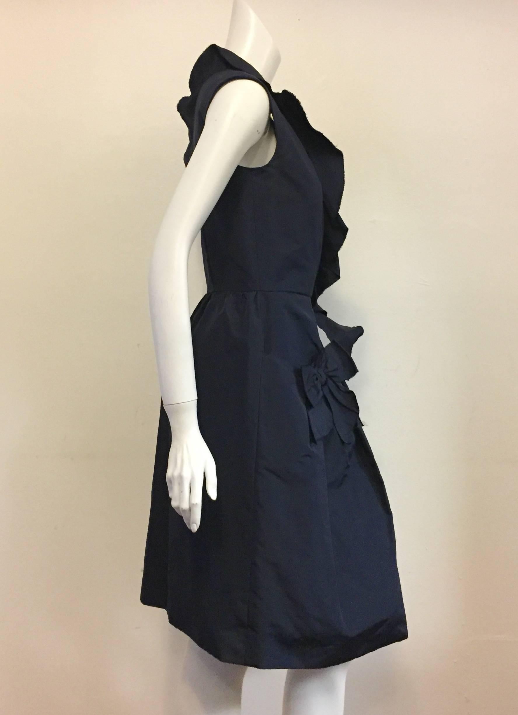 Oscar de la Renta creations are always so feminine and sophisticated they have been appreciated by aficionados for decades!  This dress speaks for itself with a deep v-neck lined with ruffles, a bow and two front pockets nodding in true homage to
