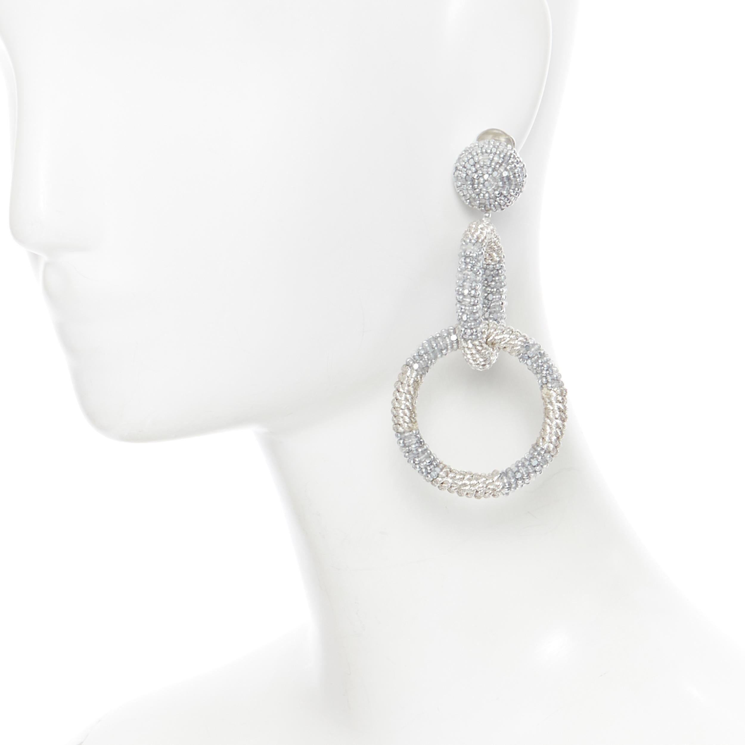 OSCAR DE LA RENTA silver bead embellished dual hoop clip on statement earring
Brand: Oscar de la Renta
Model Name / Style: Hood earring
Material: Fabric, bead
Color: Silver
Pattern: Solid
Extra Detail: Clip on earrings.

CONDITION: 
Condition: