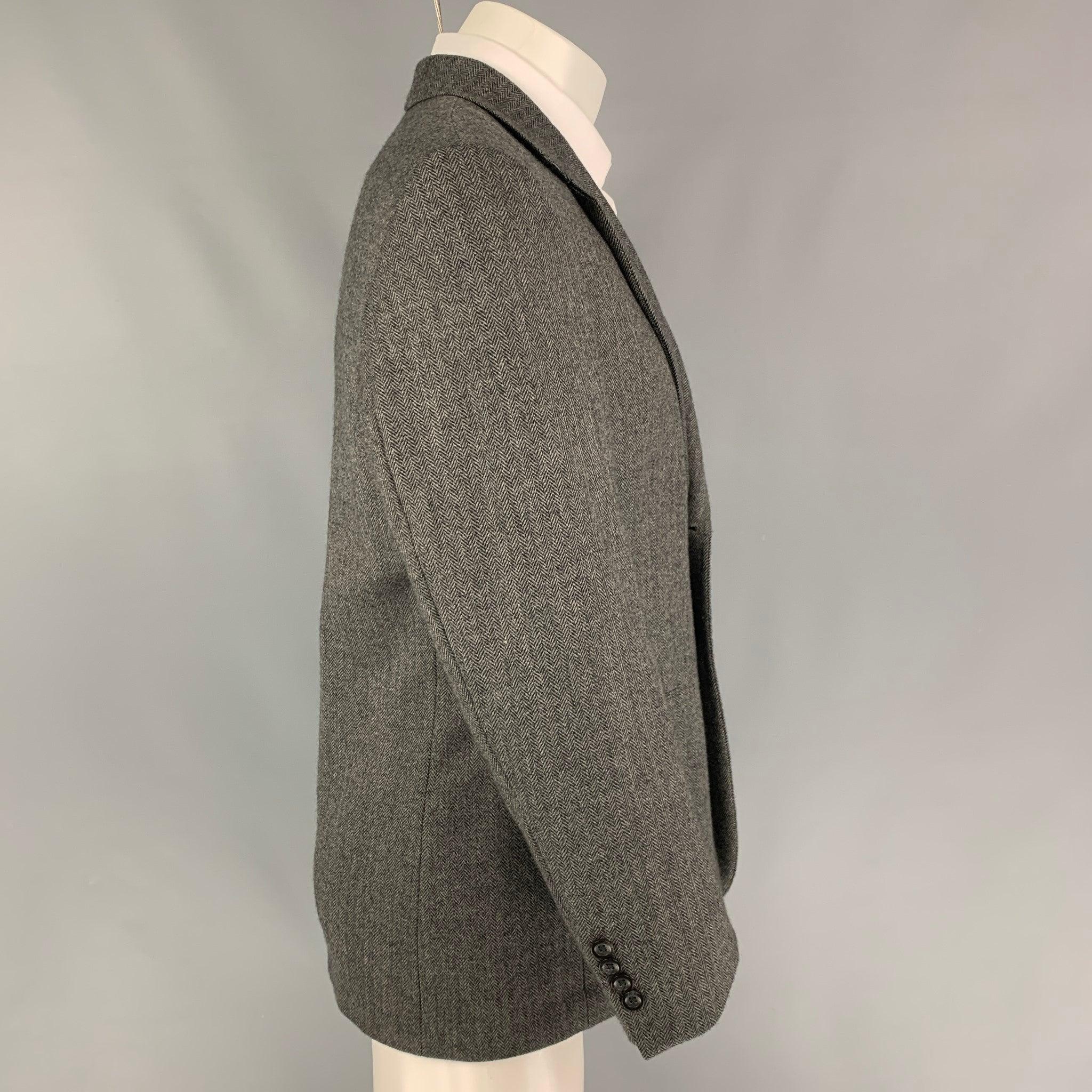 OSCAR DE LA RENTA sport coat comes in a grey & black herringbone wool featuring a notch lapel, flap pockets, and a double button closure.
Very Good
Pre-Owned Condition. 

Marked:   38 S 

Measurements: 
 
Shoulder: 18.5 inches  Chest: 38 inches 