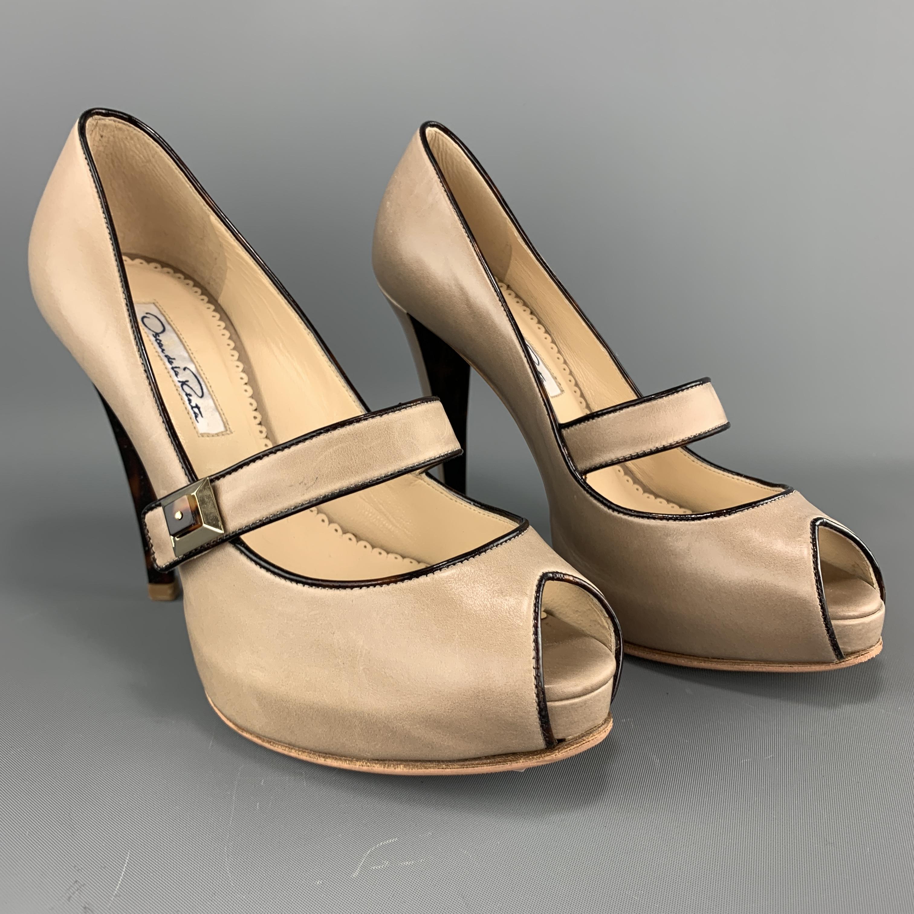 OSCAR DE LA RENTA pumps come in taupe leather with patent leather piping, peep toe, hidden platform, patent detailed heel, and Mary Jane strap with stud. Made in Italy.

Excellent Pre-Owned Condition.
Marked: IT 36

Heel: 4.25 in.
Platform: 0.75 in.