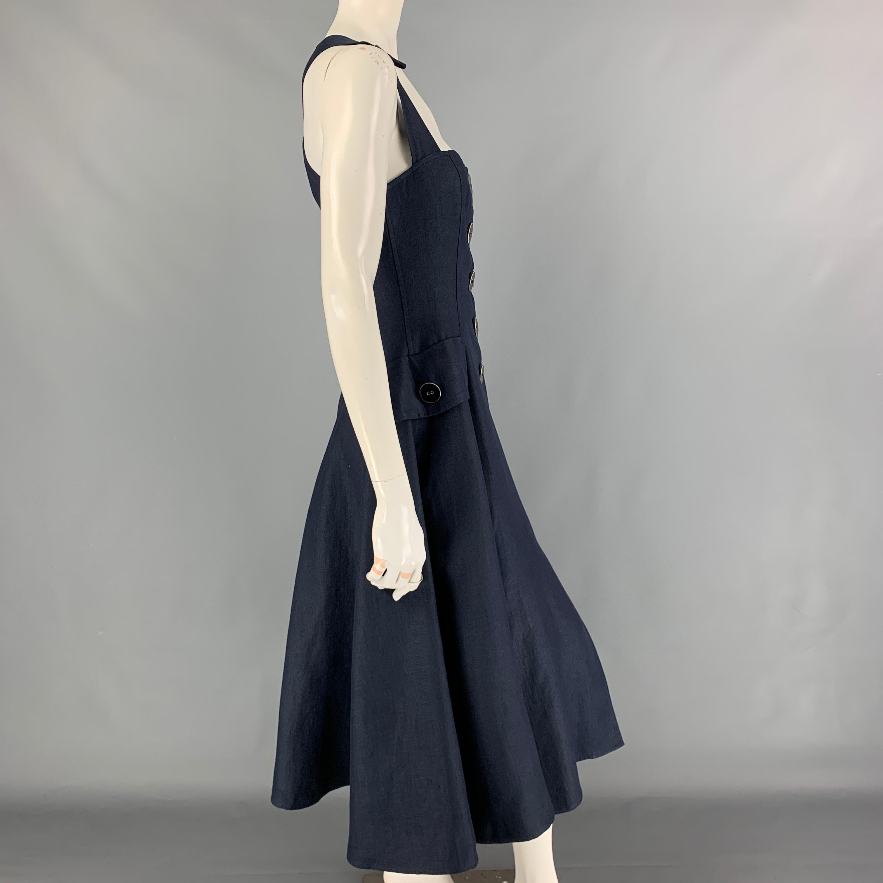 OSCAR DE LA RENTA dress comes in a navy material featuring an a-line style, flap pockets, back criss cross straps, and a large front buttoned closure. 

Very Good Pre-Owned Condition.
Marked: 8

Measurements:

Bust: 30 in.
Waist: 28 in.
Hip: 40