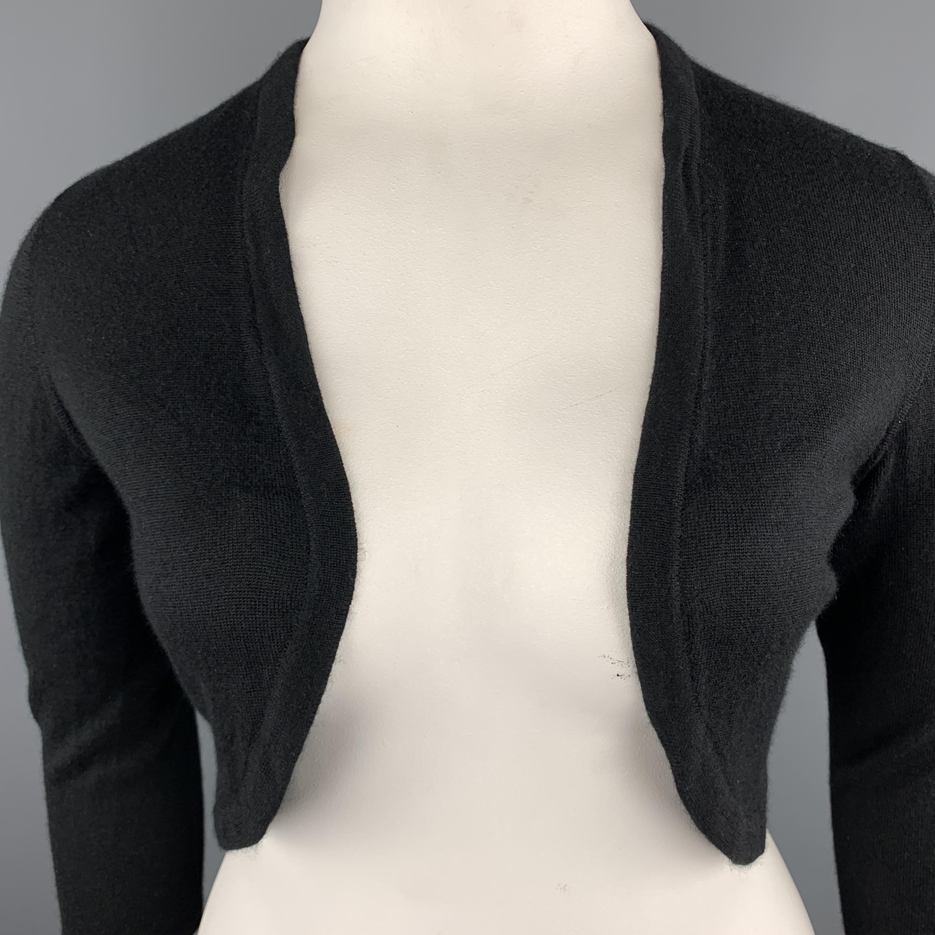 OSCAR DE LA RENTA bolero cardigan comes in fine cashmere silk blend knit with cropped sleeves and a logo embellished back. Made in USA.

Excellent Pre-Owned Condition.
Marked: L

Measurements:

Shoulder: 15 in.
Bust: 40 in.
Sleeve: 19 in.
Length: 16