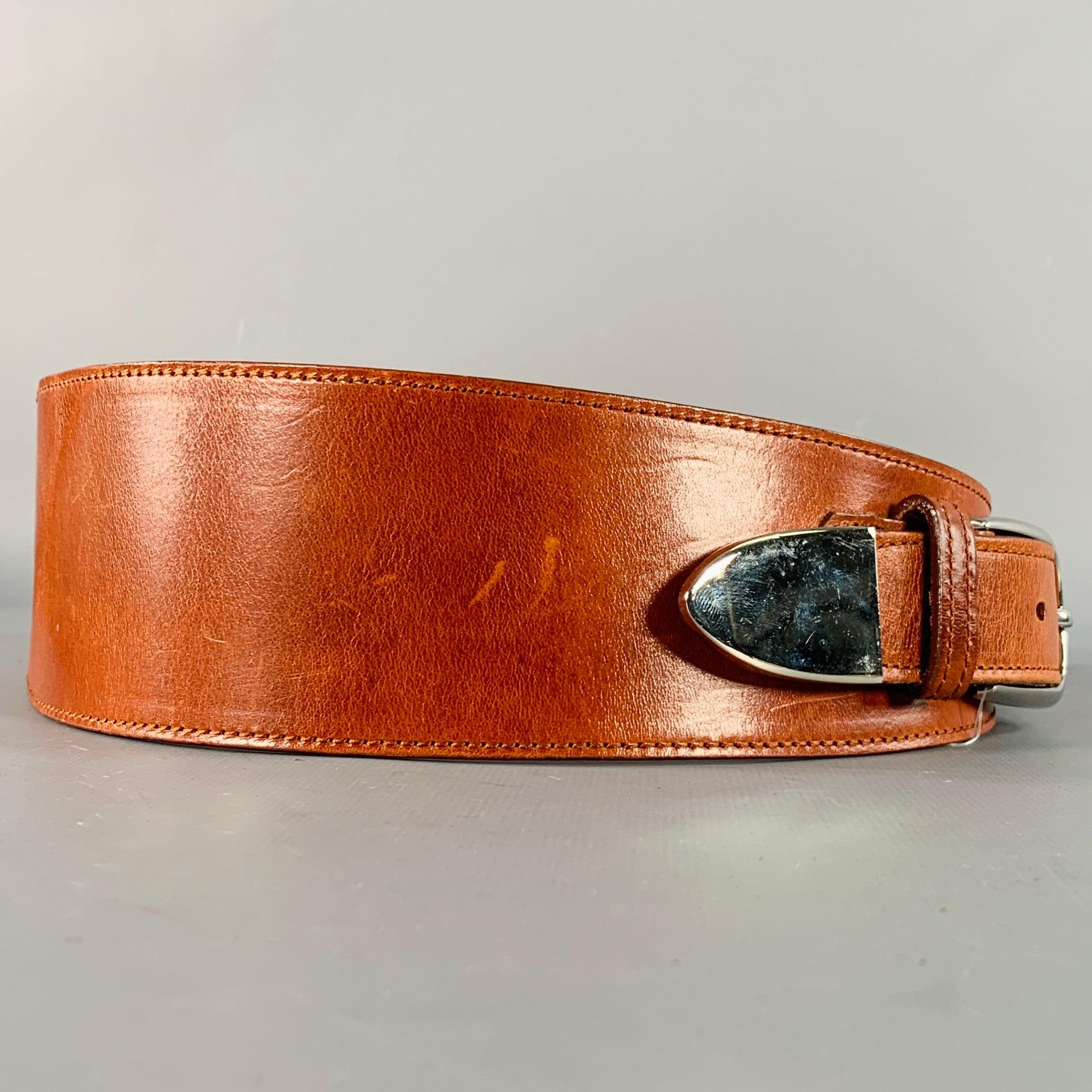 Cintura Oscar De La Renta
in pelle marrone, con uno stile ampio e un dettaglio O-ring in metallo argentato che avvolge la cintura fino alla chiusura con fibbia argentata. Made in USA. Eccellente condizione di usato. 

Contrassegnato:  
