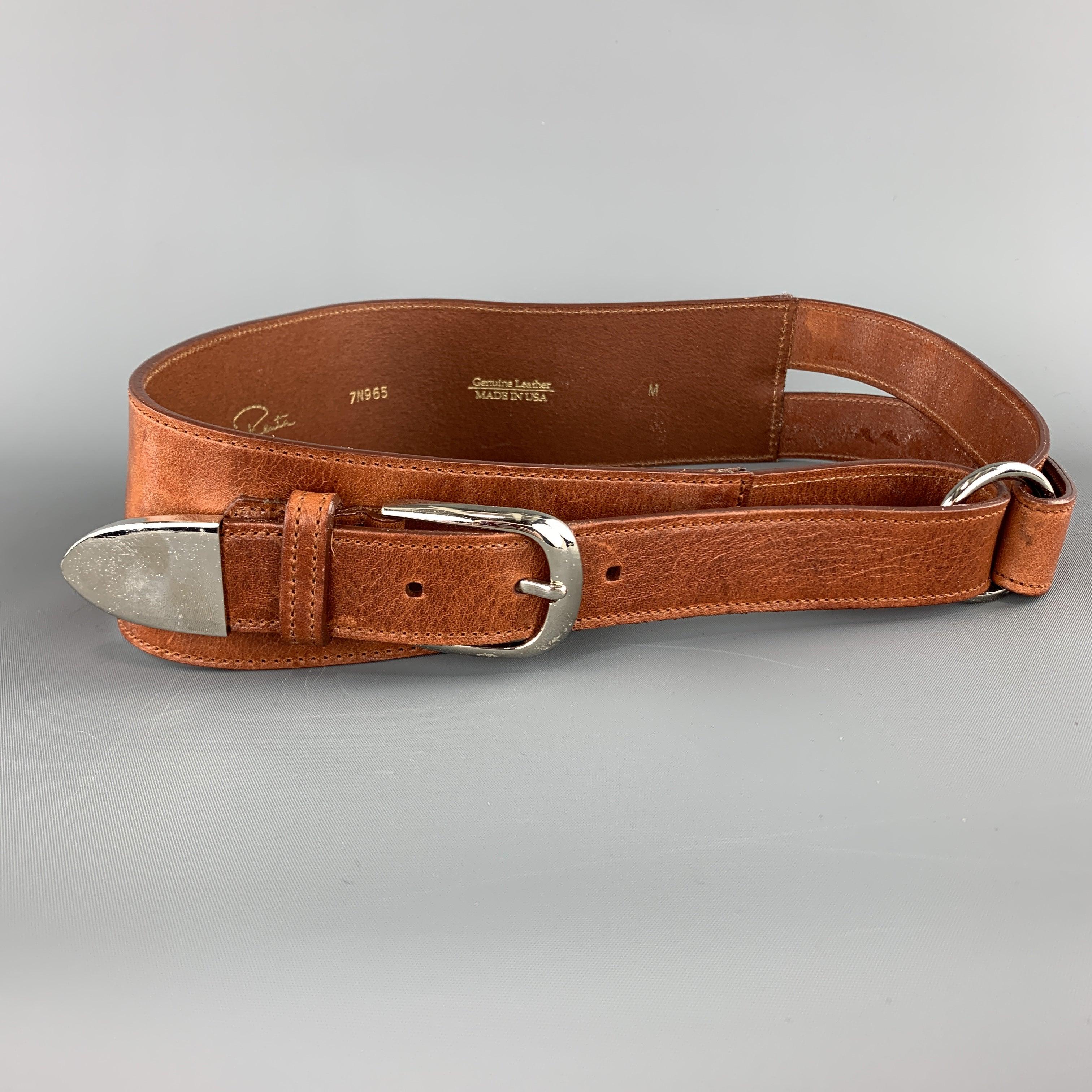 OSCAR DE LA RENTA belt comes in tan leather with a loop buckle wrap closure accented with silver tone hardware. Minor wear. Made in USA.
Good
Pre-Owned Condition. 

Marked:   MWidth: 3 inches Minimum Fit: 30 inches Maximum Fit: 32 inches 
  
  
