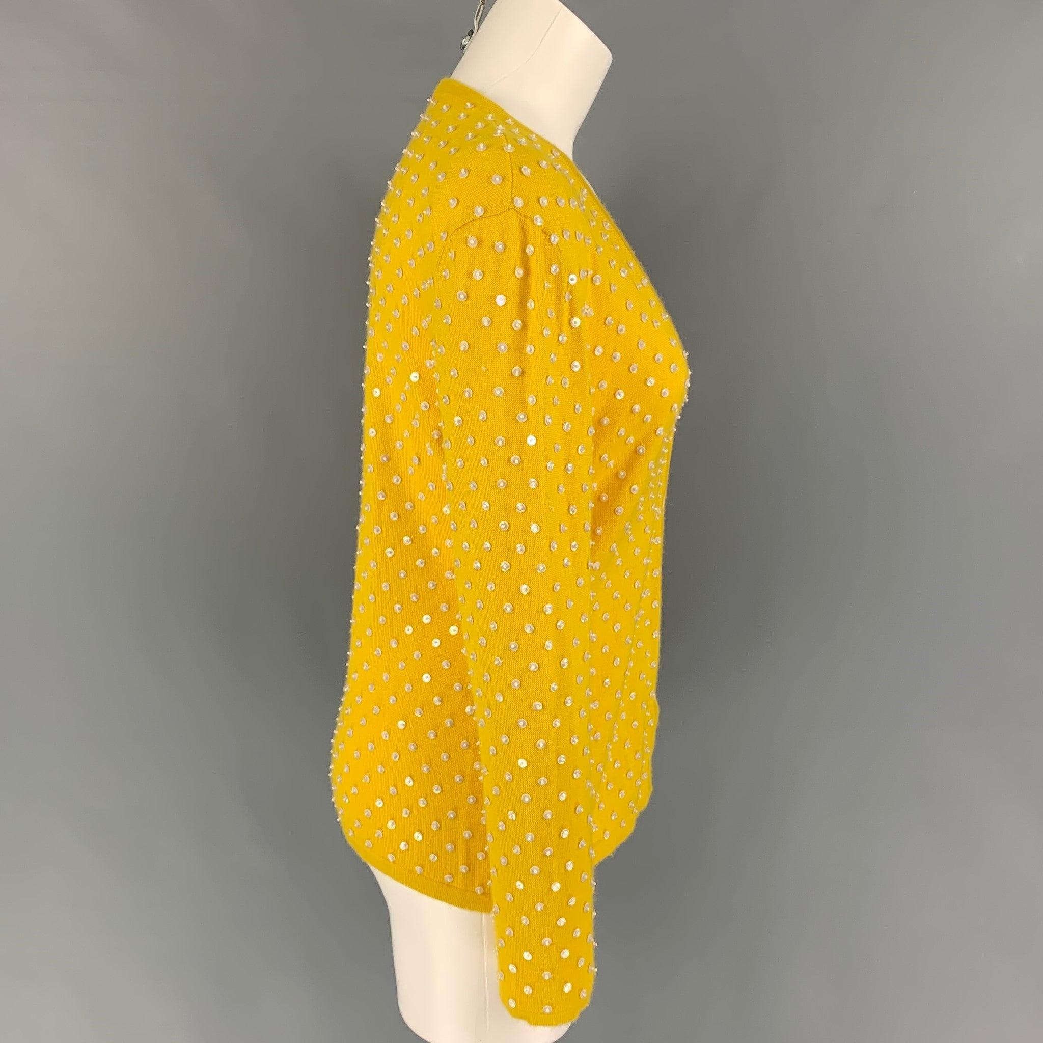 OSCAR DE LA RENTA cardigan comes in a yellow cashmere featuring beaded embellishments and a buttoned closure. Matching sleeveless pullover sold separately.
Very Good
Pre-Owned Condition. Logo & Fabric tag removed.  

Marked:   M  

Measurements: 
