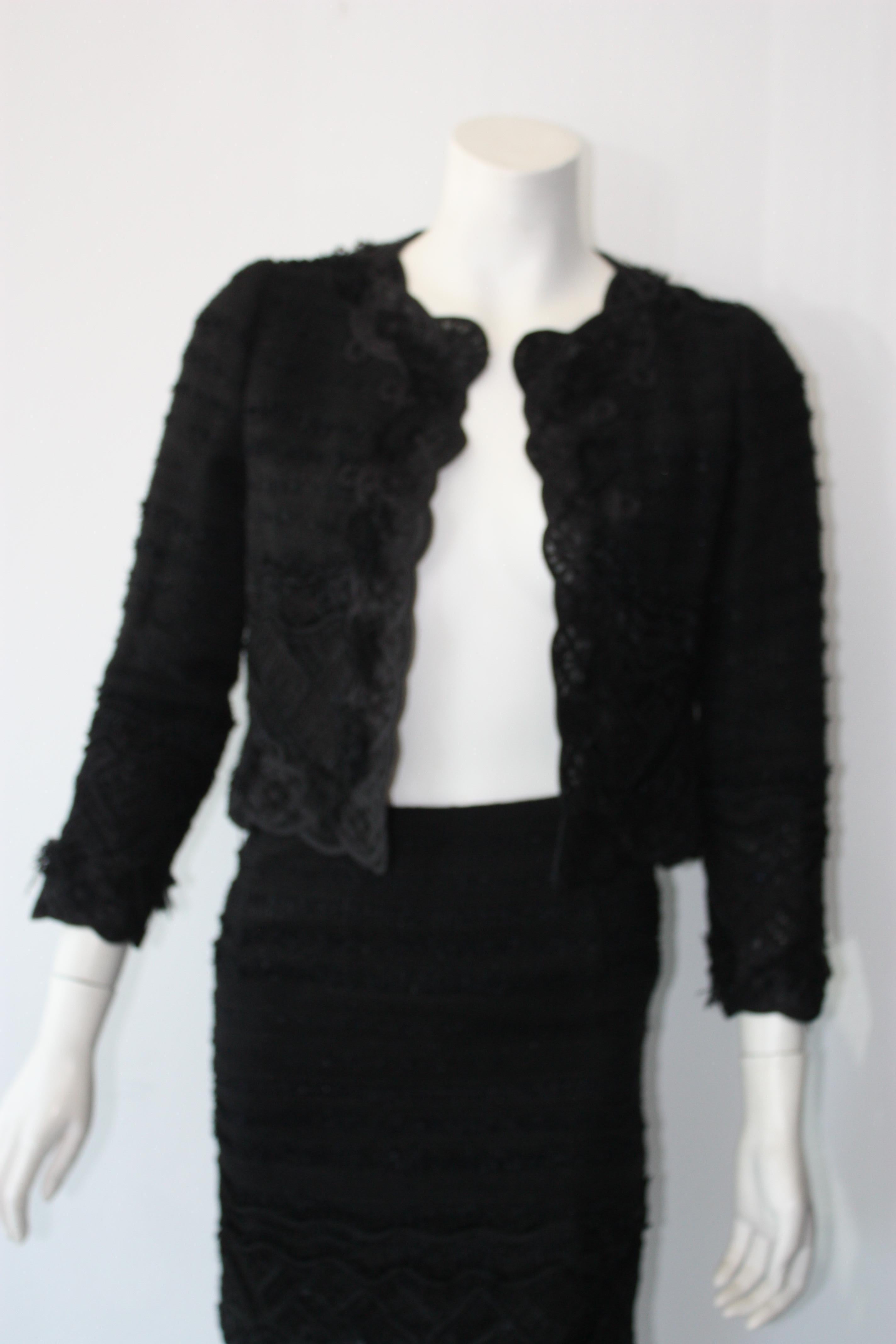 Oscar De La Renta black tweed skirt suit with tonal applique embellishments.
MINT condition. 
So chic - Jackie O' look 
Size 2 .

Jacket: 100% silk. Trim: 39% cotton, 14% acetate, 23% ramie, 19% nylon, 5% polythylene. Lining: 100% silk.
Skirt: 100%