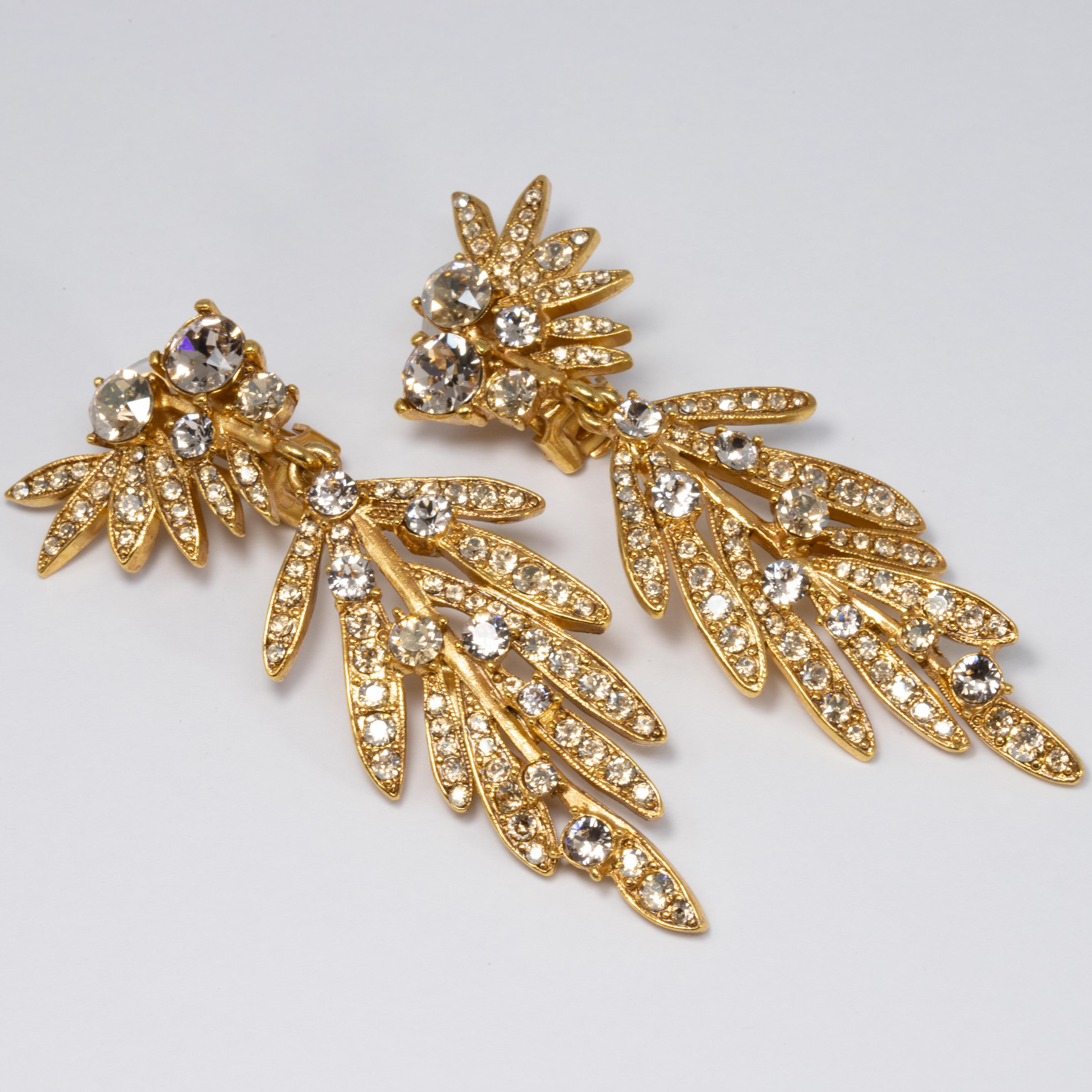 An exquisite pair of earrings by Oscar de la Renta! Each earring features dangling gold-plated tropical leaves accented with clear Swarovski crystals. 

Hallmarks: Oscar de la Renta, Made in USA