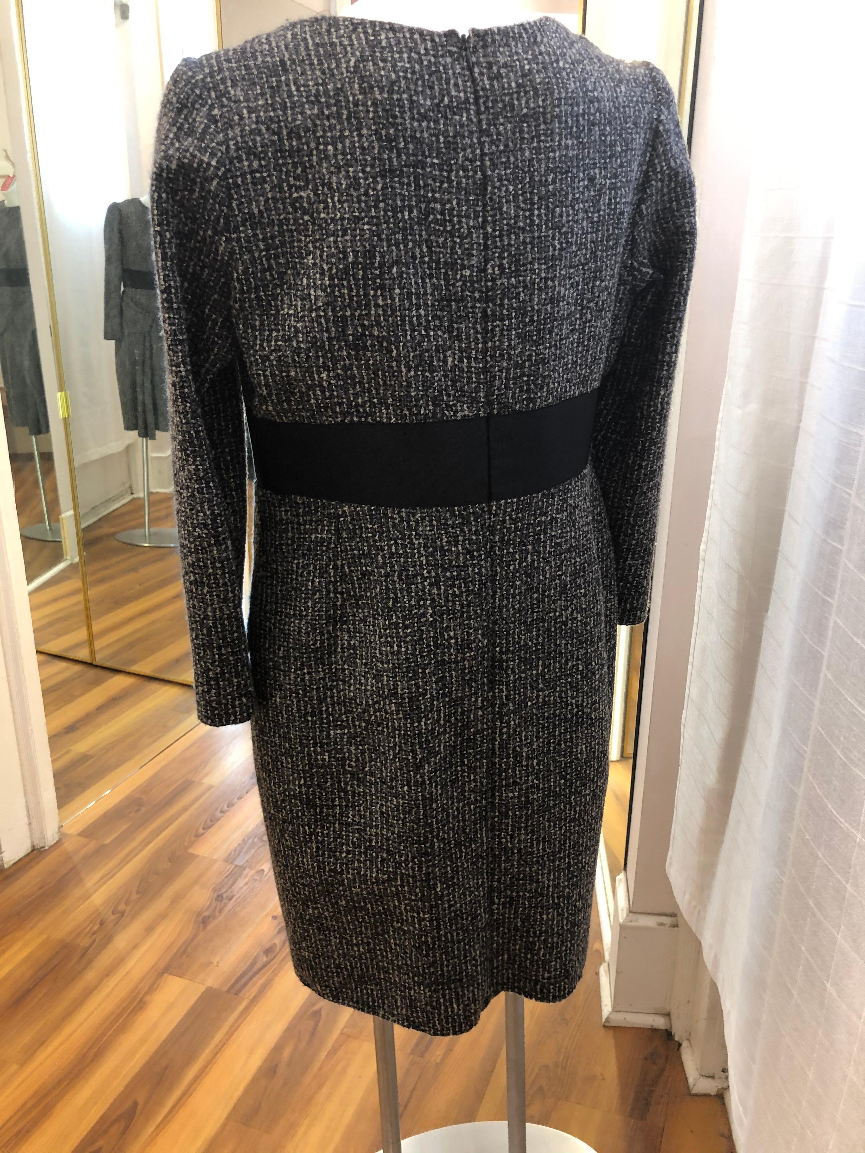 Black, grey and white tweed dress, made in Italy, with a silk lining and a gros grain black waist bend.
The tailoring is impeccable, and there are very distinctive folds on one side of the hips.