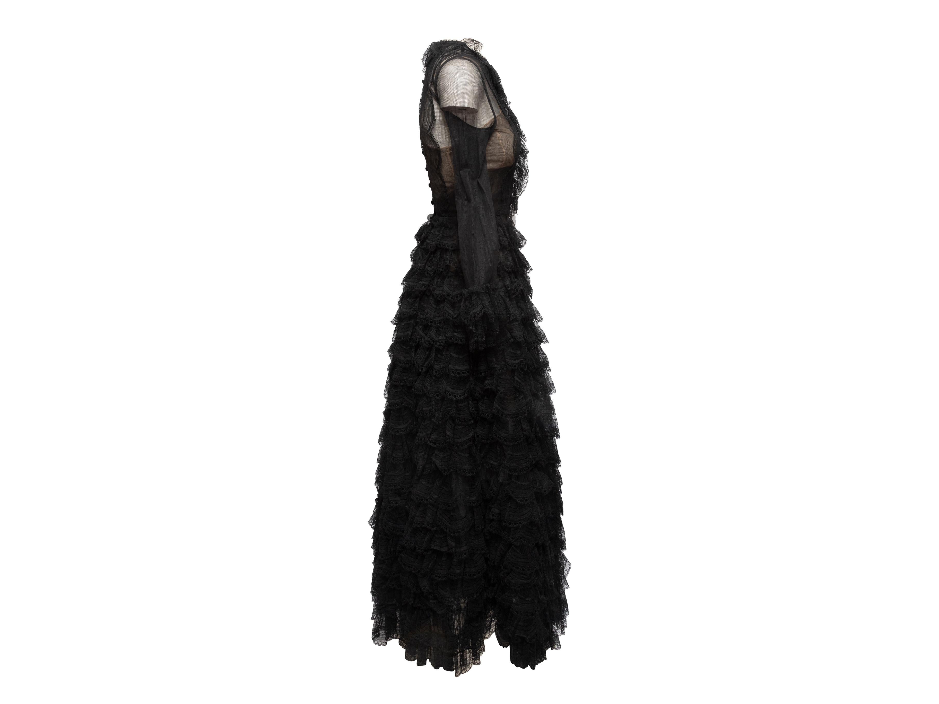 Product Details: Vintage black sheer lace evening gown by Oscar de la Renta. Crew neck. Ruffle trim at cuffs and crew neck. Tiered skirt. Button closures at center back. 28