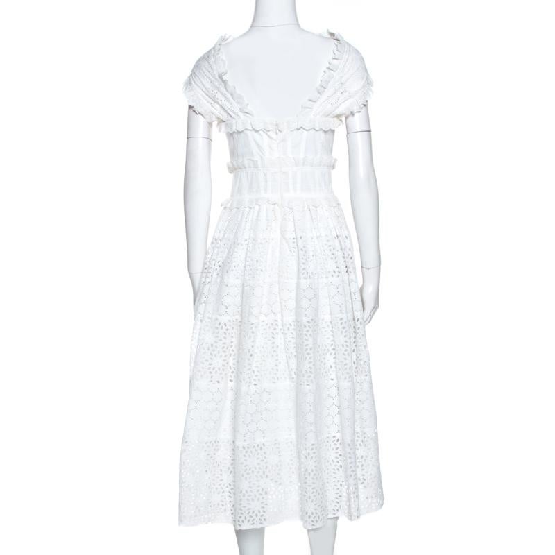 A breathtaking creation from Oscar de la Renta, this dress is a beautiful blend of femininity and class with a visual and tactile appeal. It is decorated with cross straps at the bodice and is fitted at the waist with eyelets on the skirt. Designed