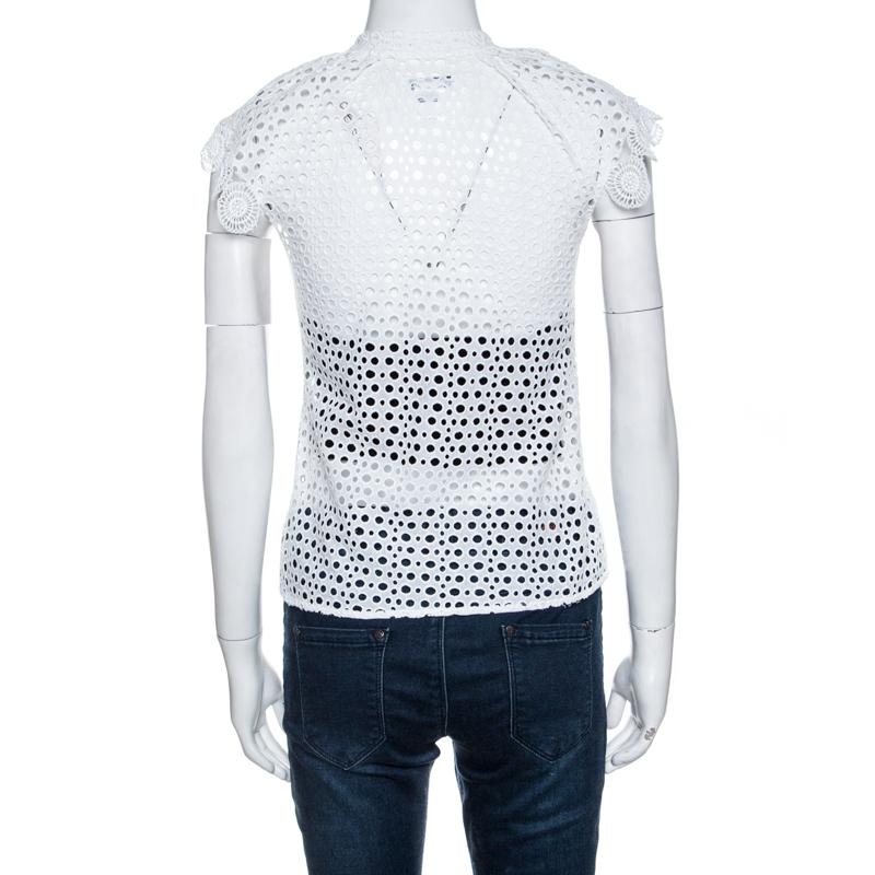Lend a modern take on fashion with this excellent Oscar de la Renta top. This white top has eyelets all over and ruffles lace trims on the neckline. Adorned with a gorgeous design, this beautiful top is made from 100% cotton.

