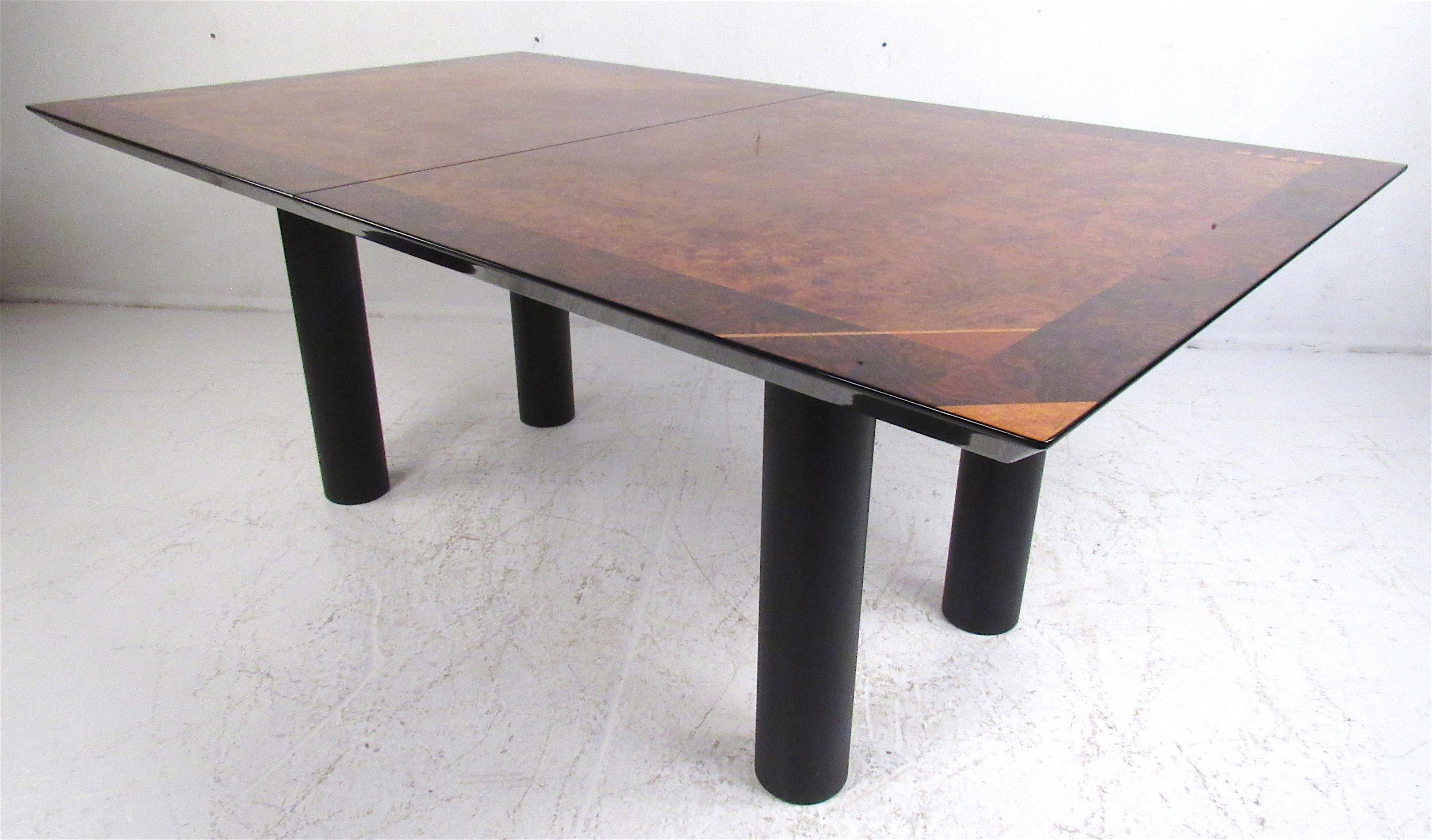 A sleek Italian design that boasts a burl and rosewood top with a stunning lacquered finish and geometric inlays. This unusual table includes one leaf allowing it to extend an additional 19.5 inches in width.
Please confirm location NY or NJ.